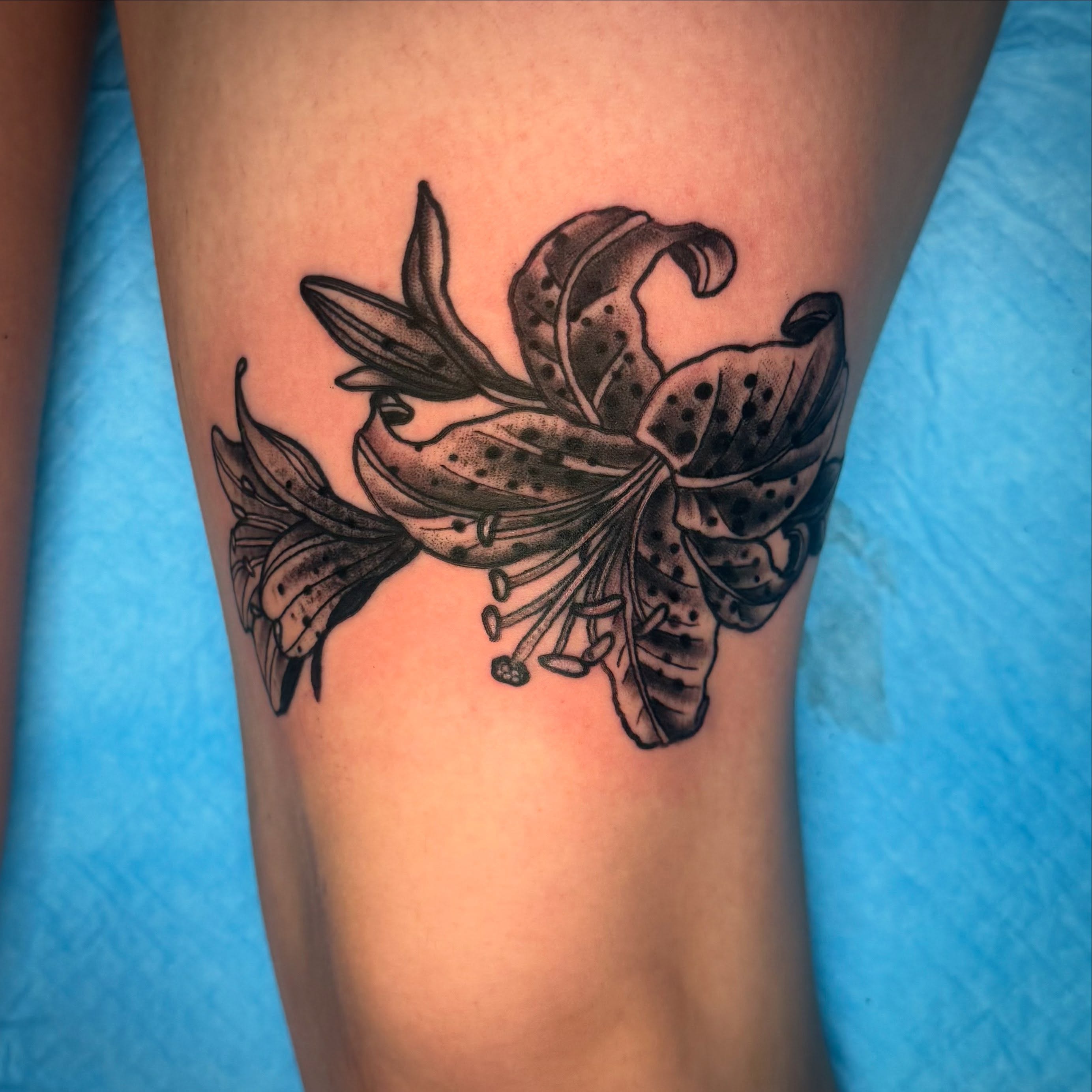 Lily dotwork tattoo on the thigh by Arron Albaugh
