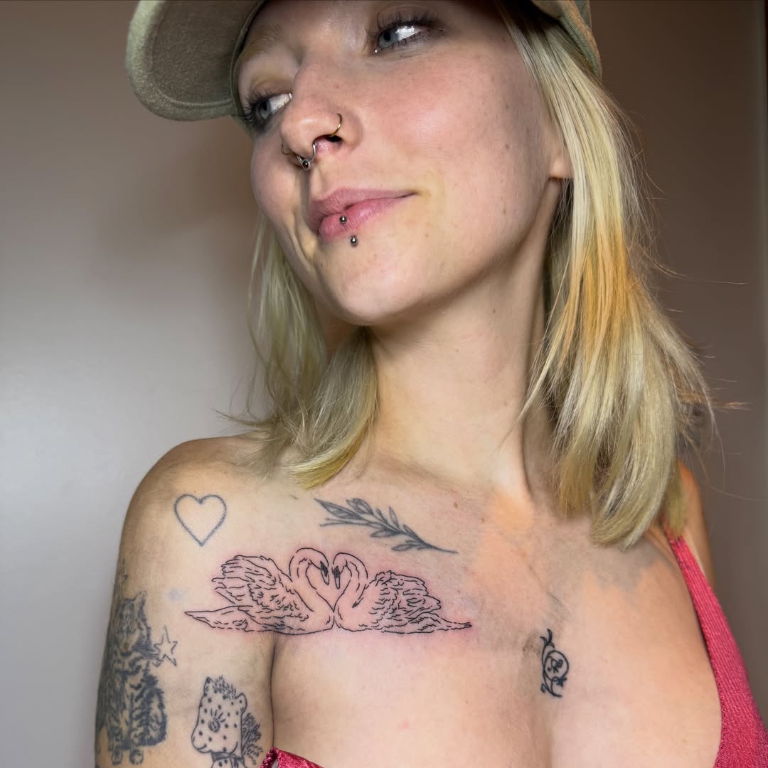 Swan and heart black and grey tattoo on the chest by Kieara West