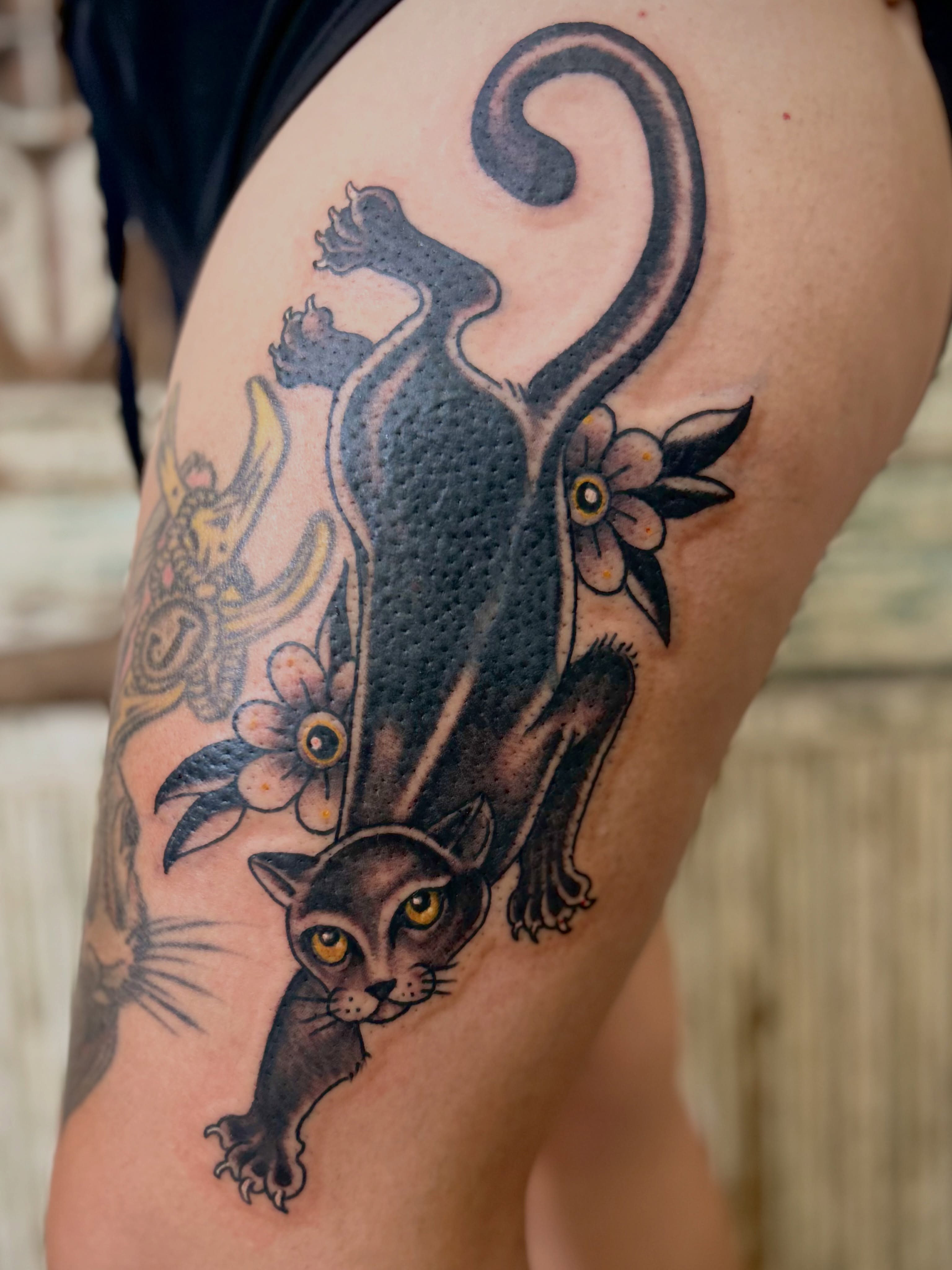 Cat and flowers American traditional tattoo on the thigh by Ryan Willard, Denver, Colorado