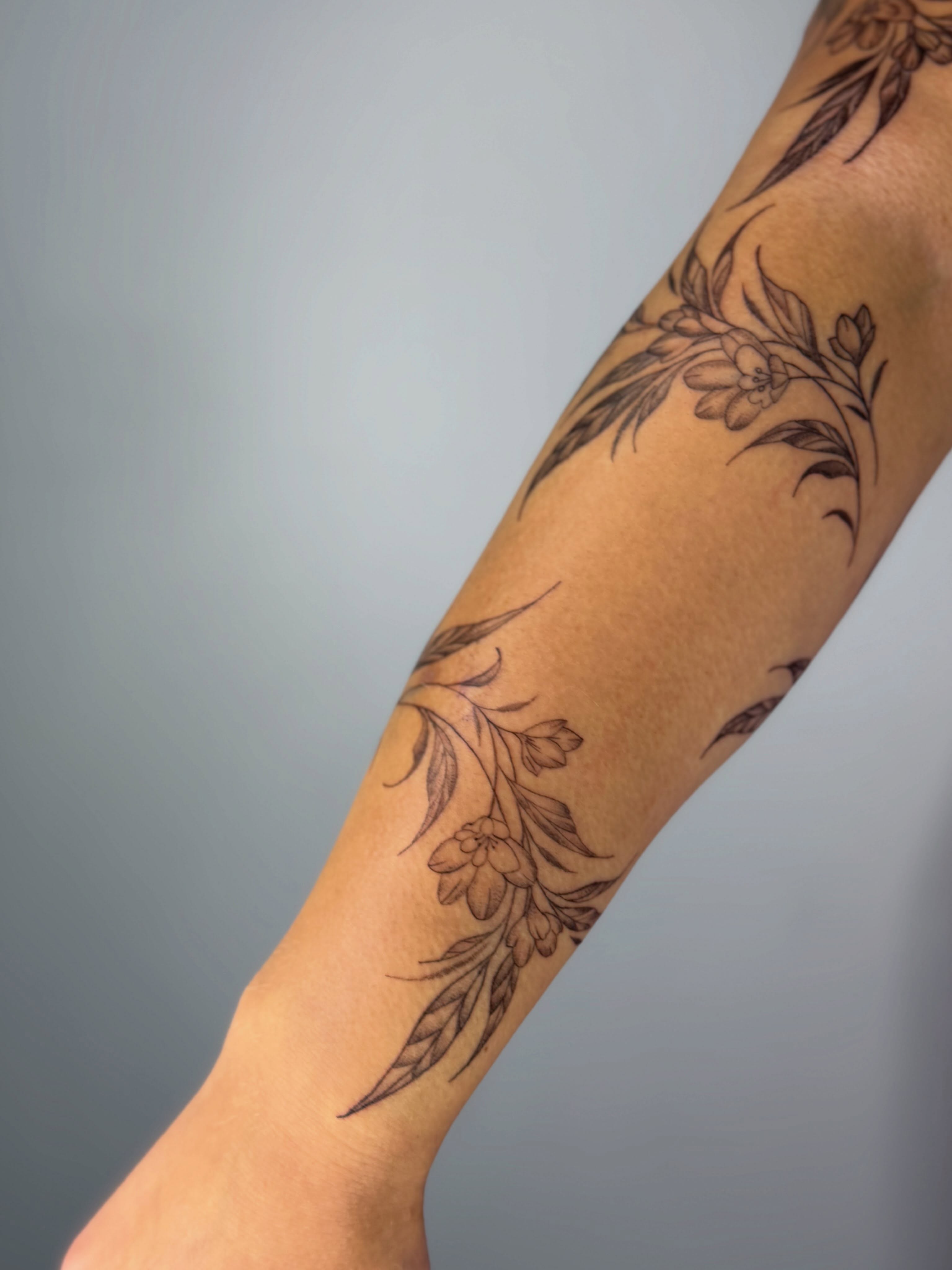 Floral design black and grey tattoo on the forearm by Silva Wellen