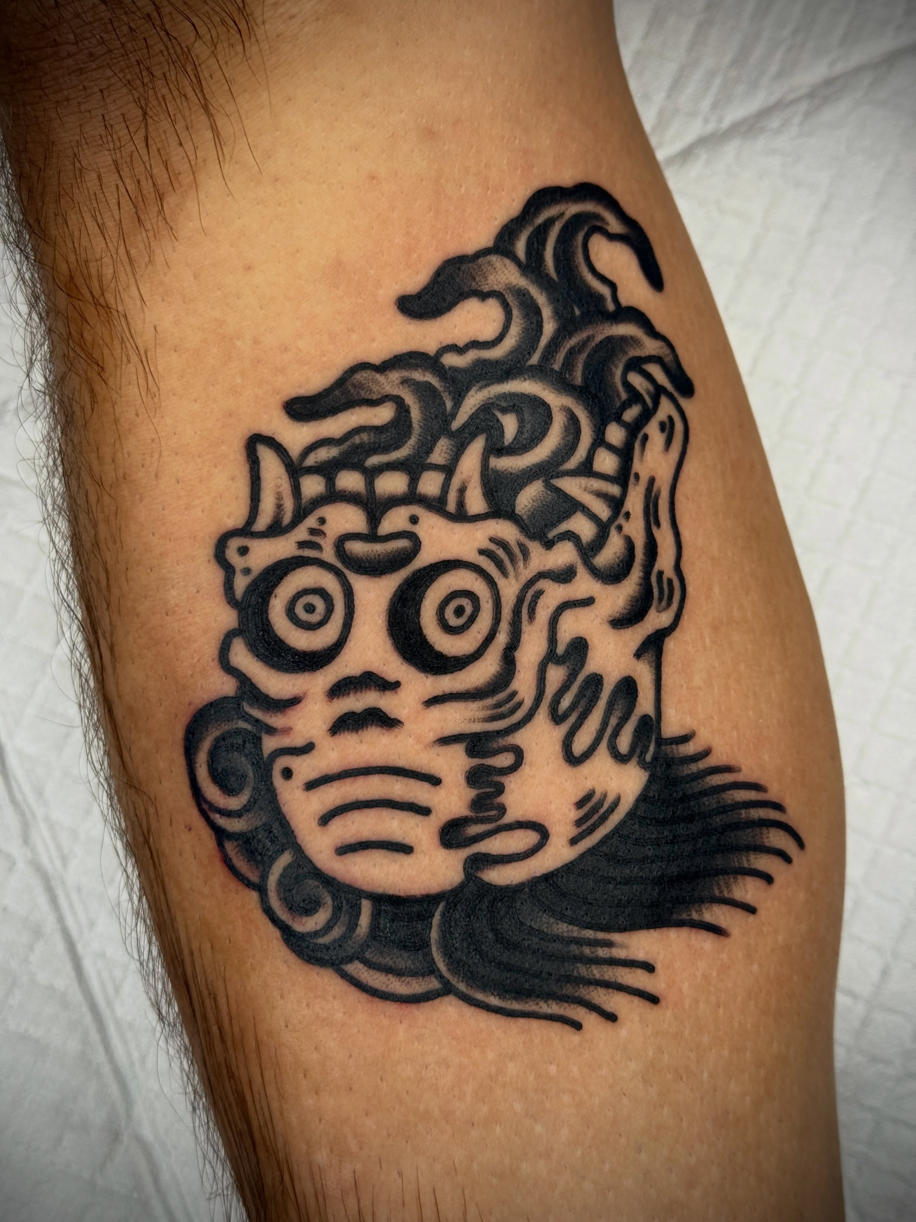 Mask black and grey tattoo on the thigh by Butch Mickle