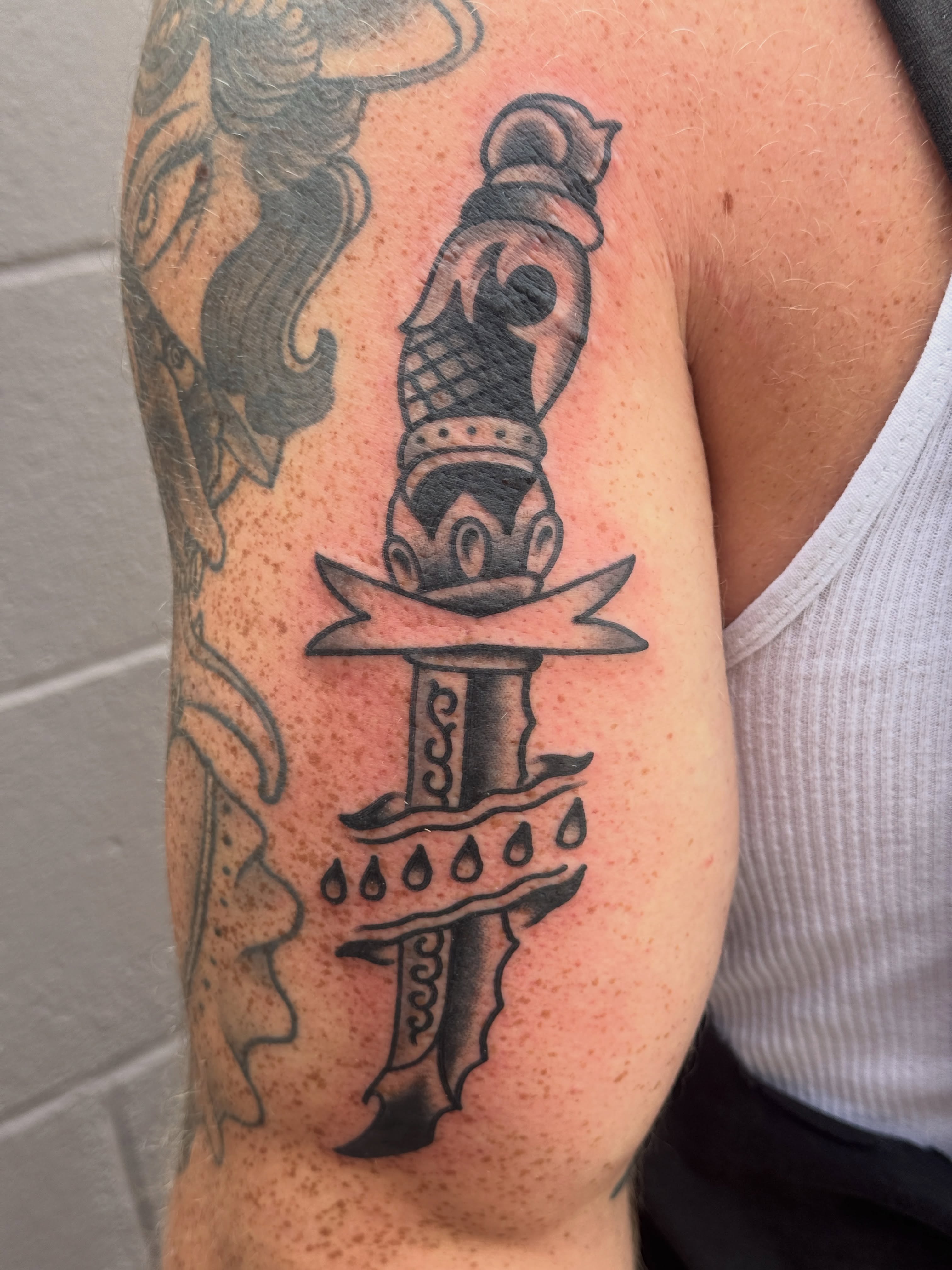 Sword black and grey tattoo on the forearm by Butch Mickle