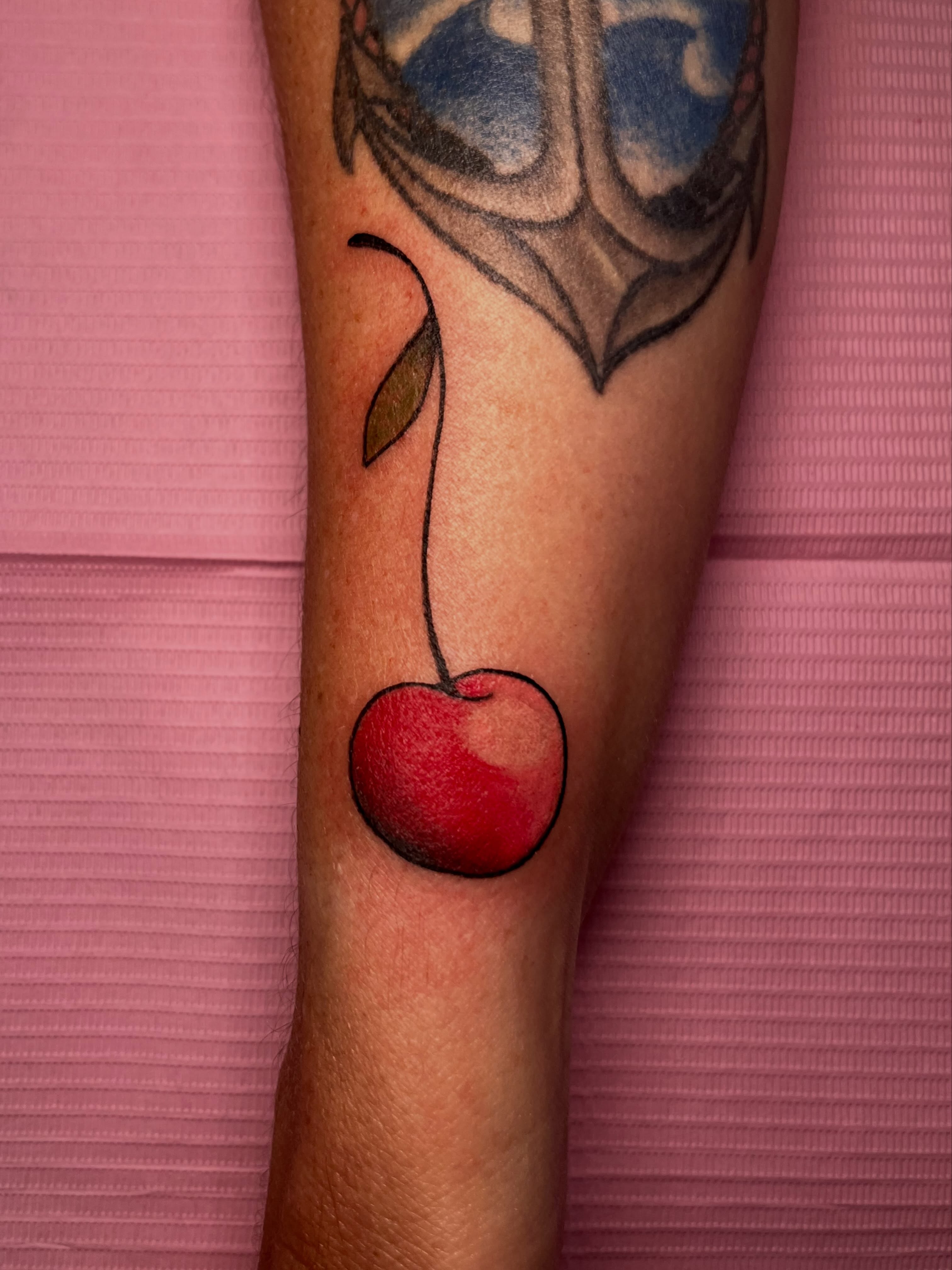 Cherry realism tattoo on the forearm by Hannah Hahn