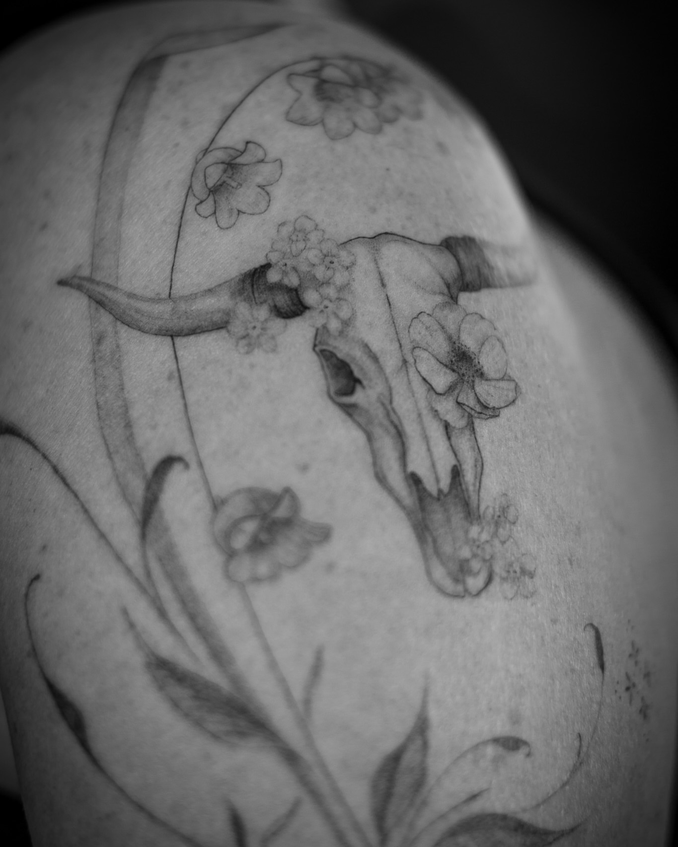 Bull skull with flowers black and grey tattoo on the shoulder by Aries Rising