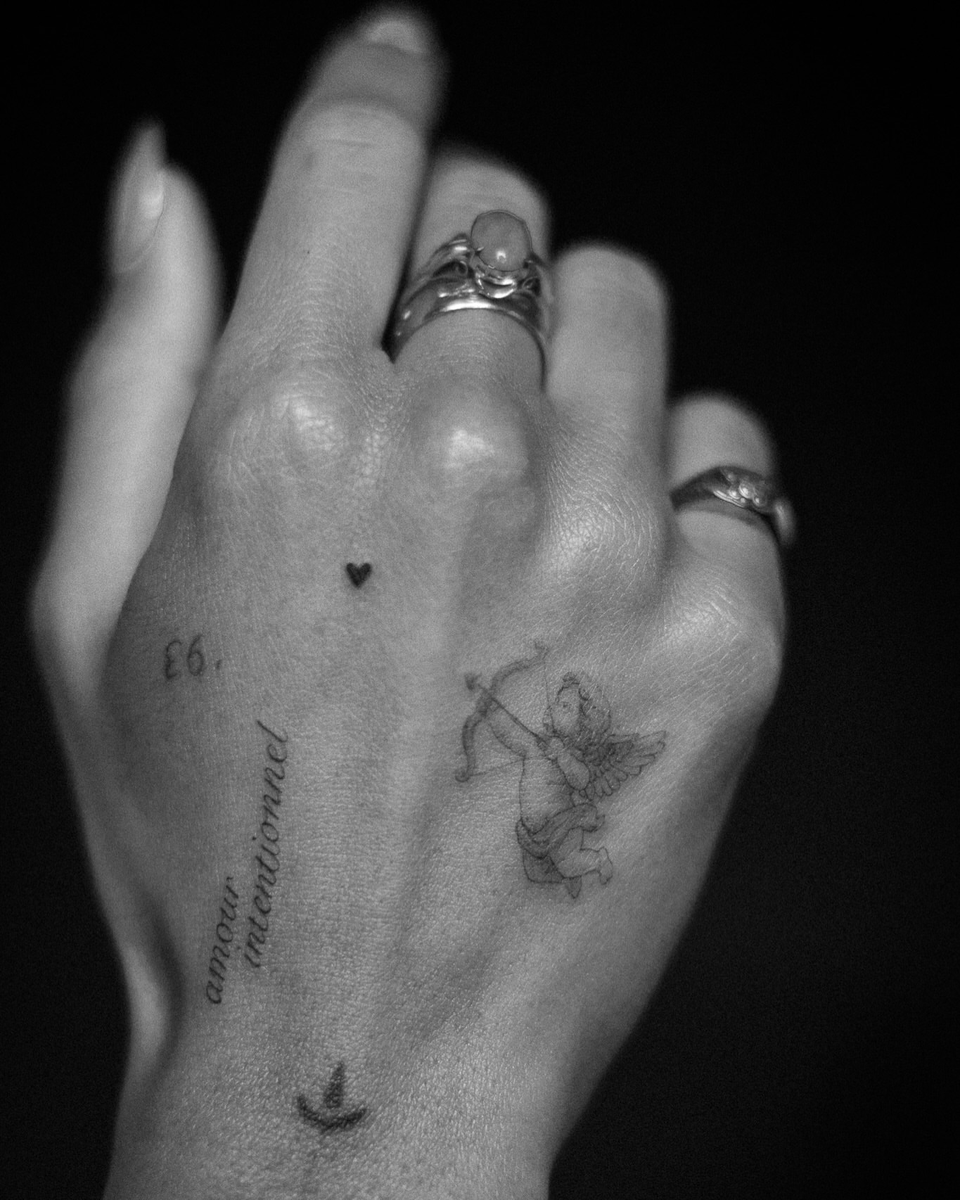 Cupid and heart black and grey tattoo on the hand by Aries Rising