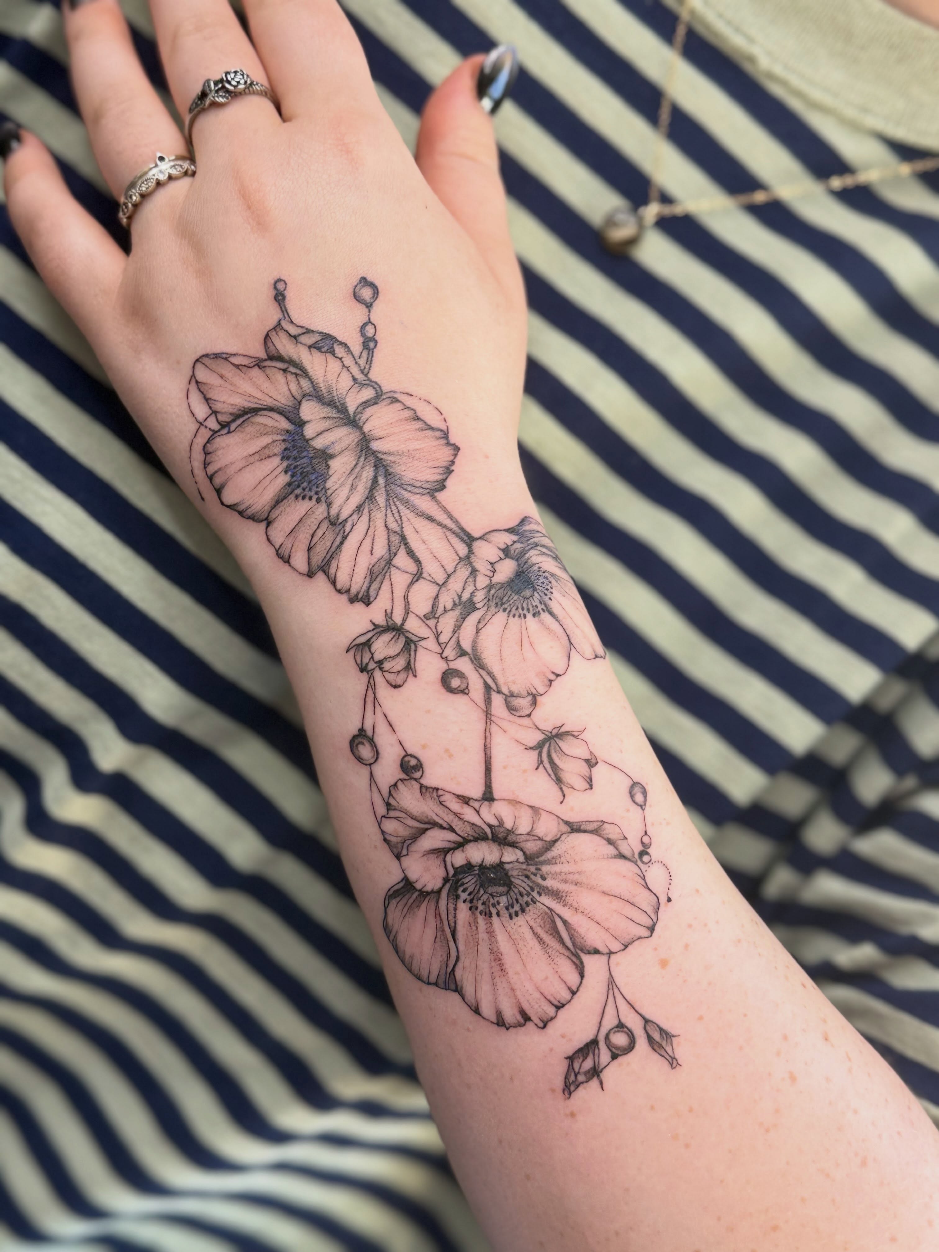 Flowers black and grey tattoo on the forearm by Tetiana