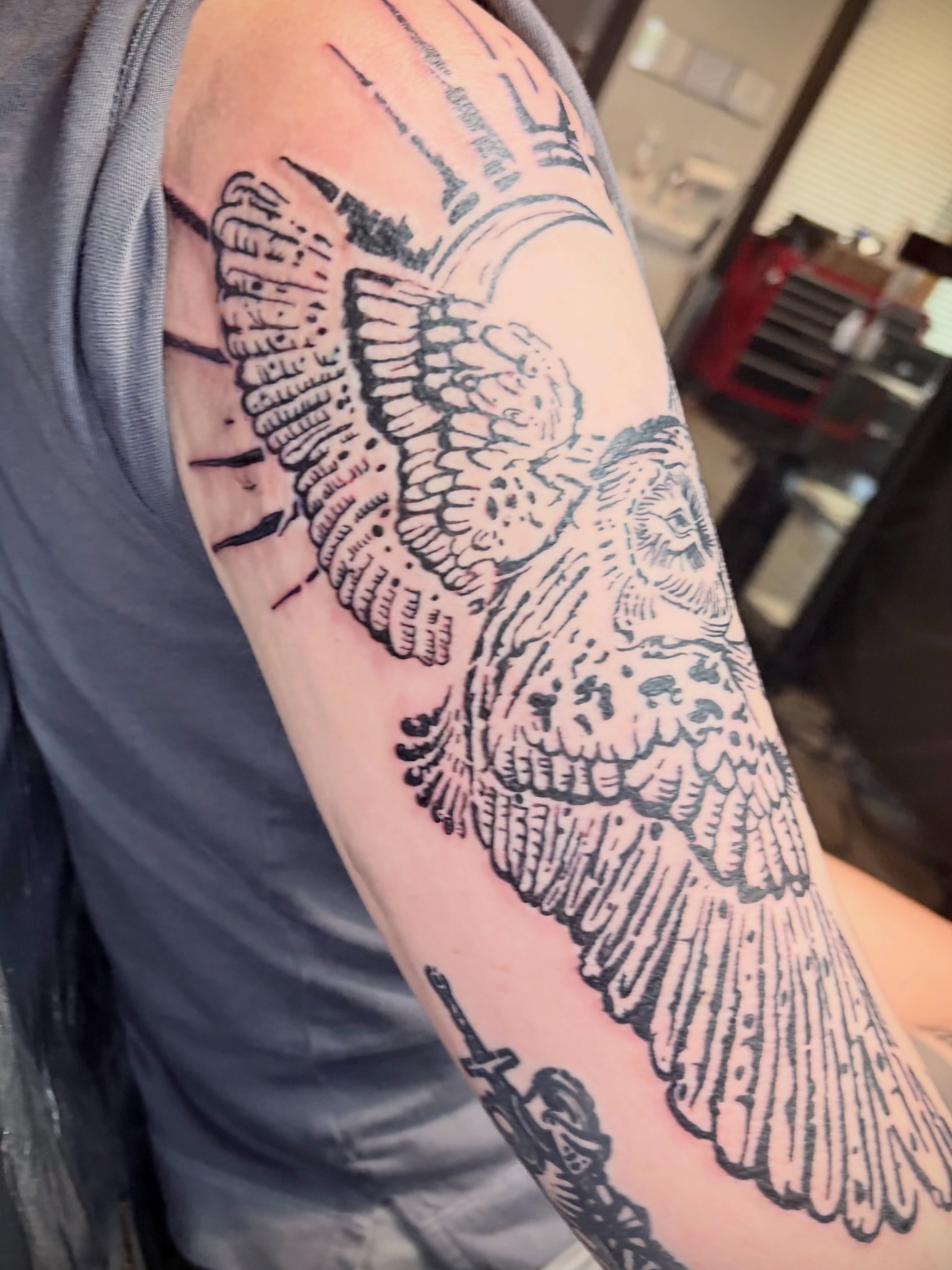 Wings and skull black and grey tattoo on the forearm by Calen Copeland