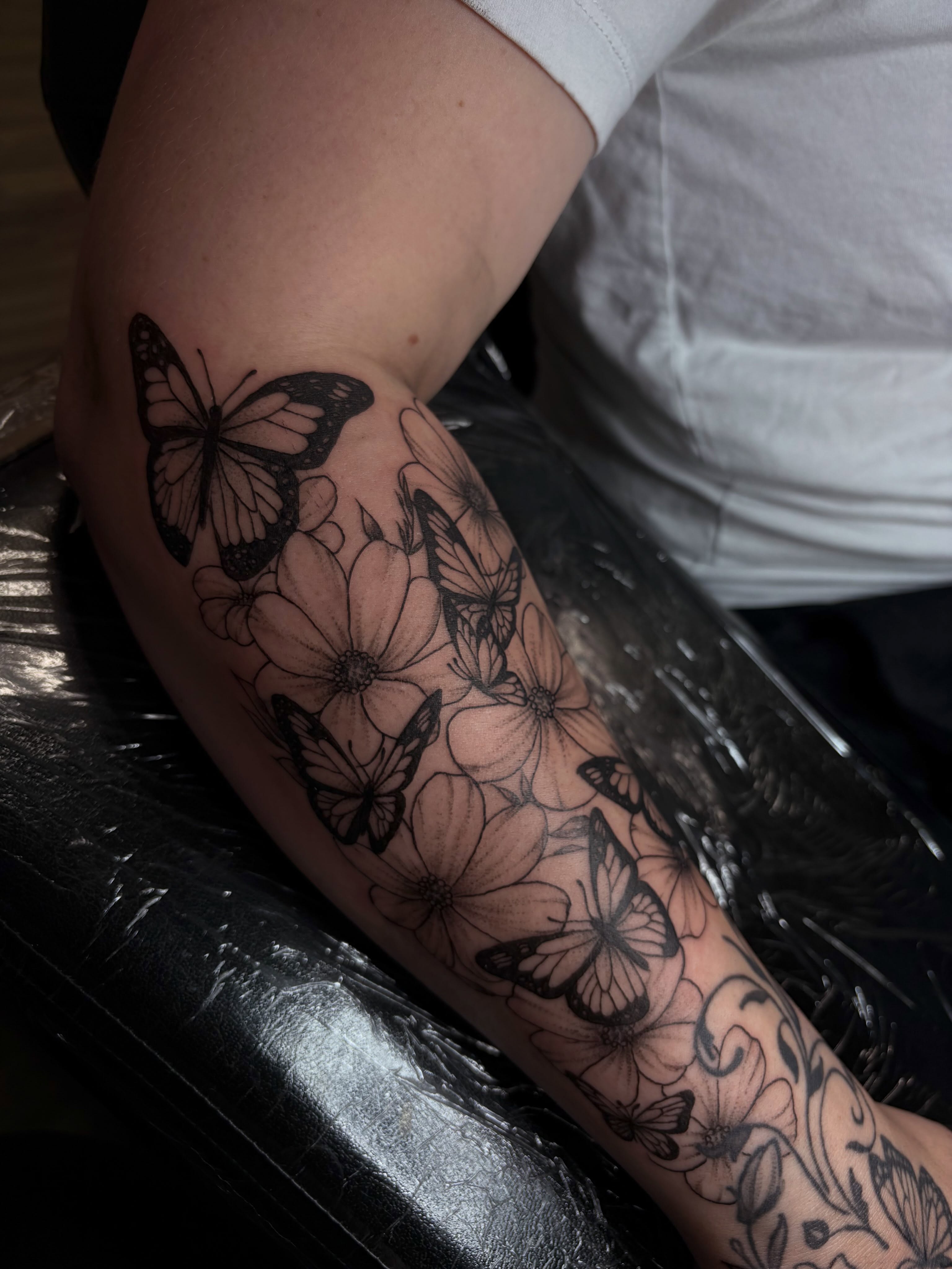 Butterflies and flowers black and grey tattoo on the forearm by Cincinnati Tattoo Artist