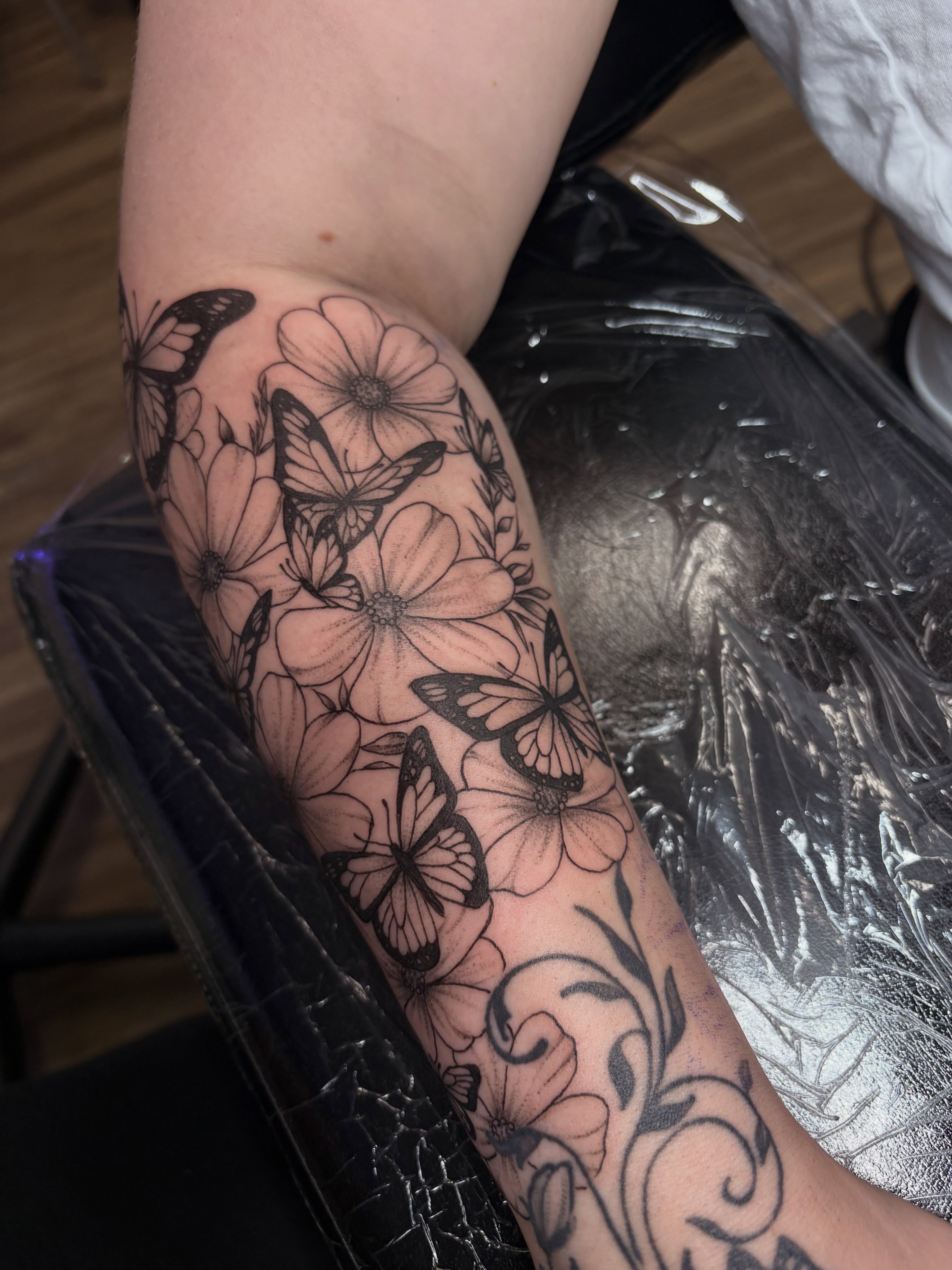 Butterflies and flowers black and grey tattoo on the forearm by Cincinnati Tattoo Artist