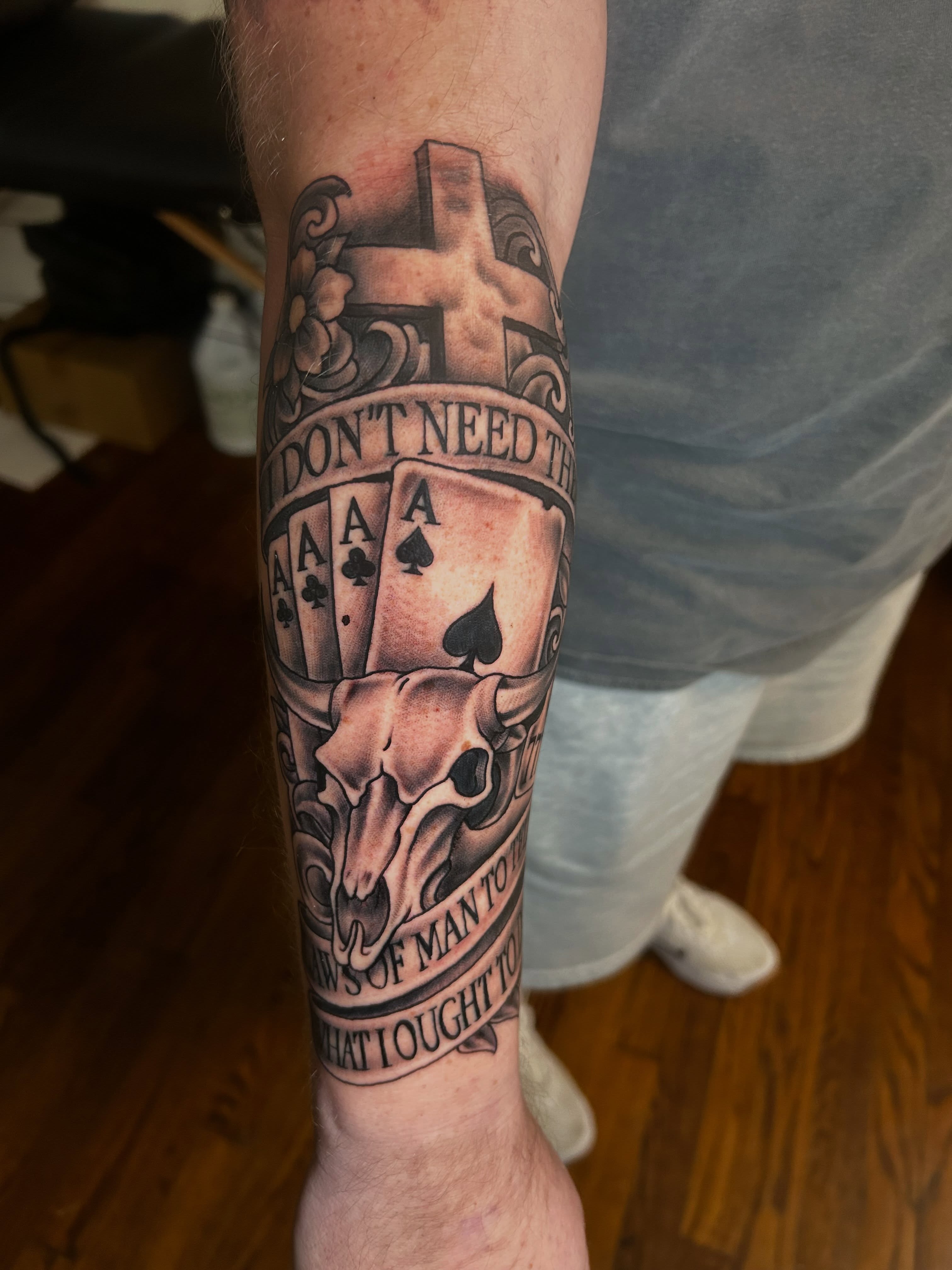 Playing cards and skull American traditional tattoo on the forearm by Austin Young
