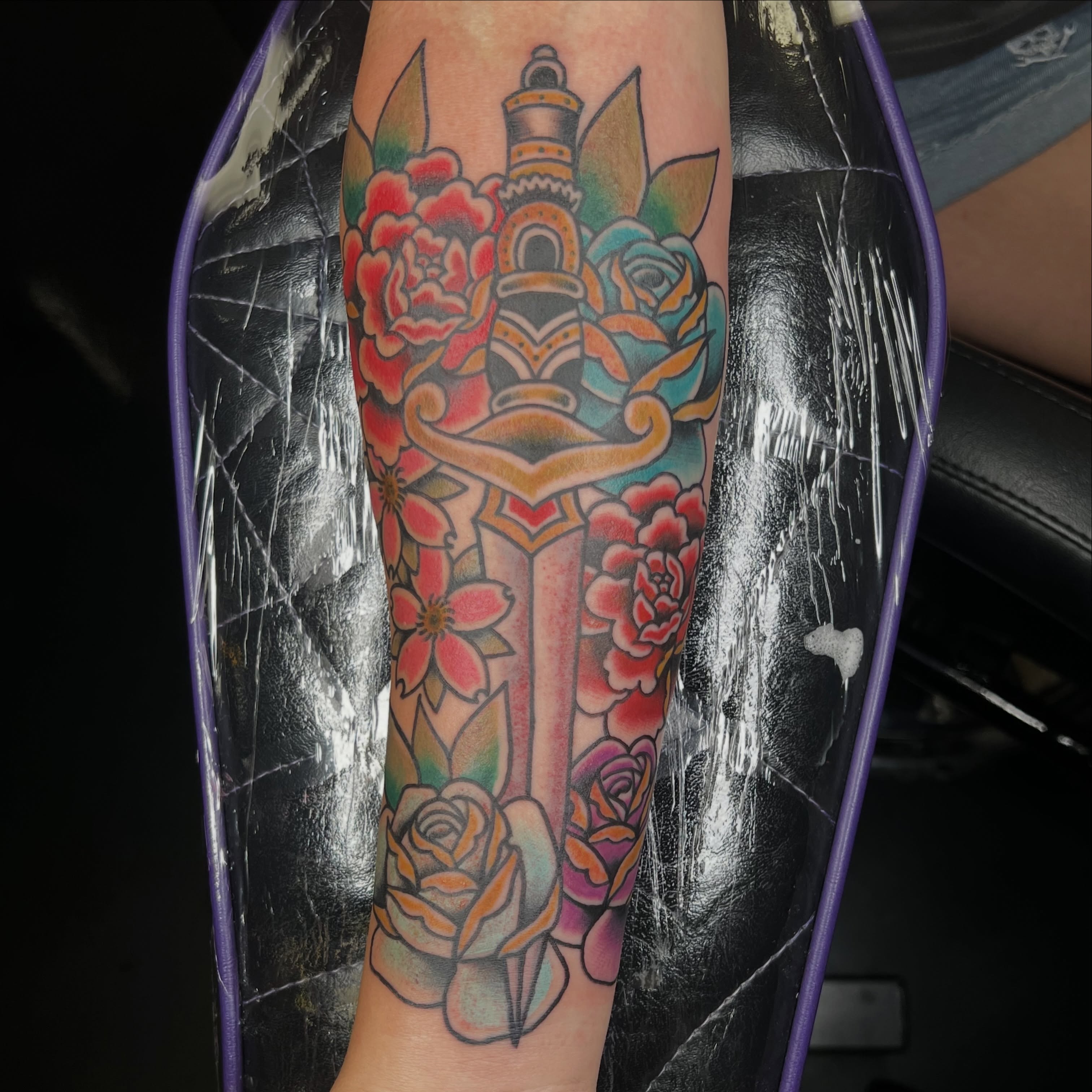 Sword and flowers American traditional tattoo on the forearm by Brian Mock