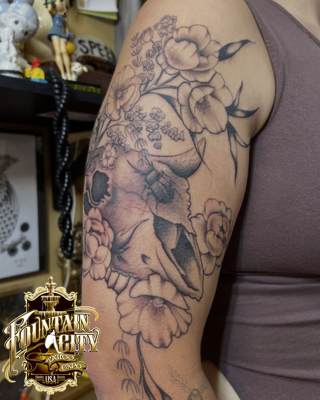 Skull and flowers realism tattoo on the shoulder by Emily Queen