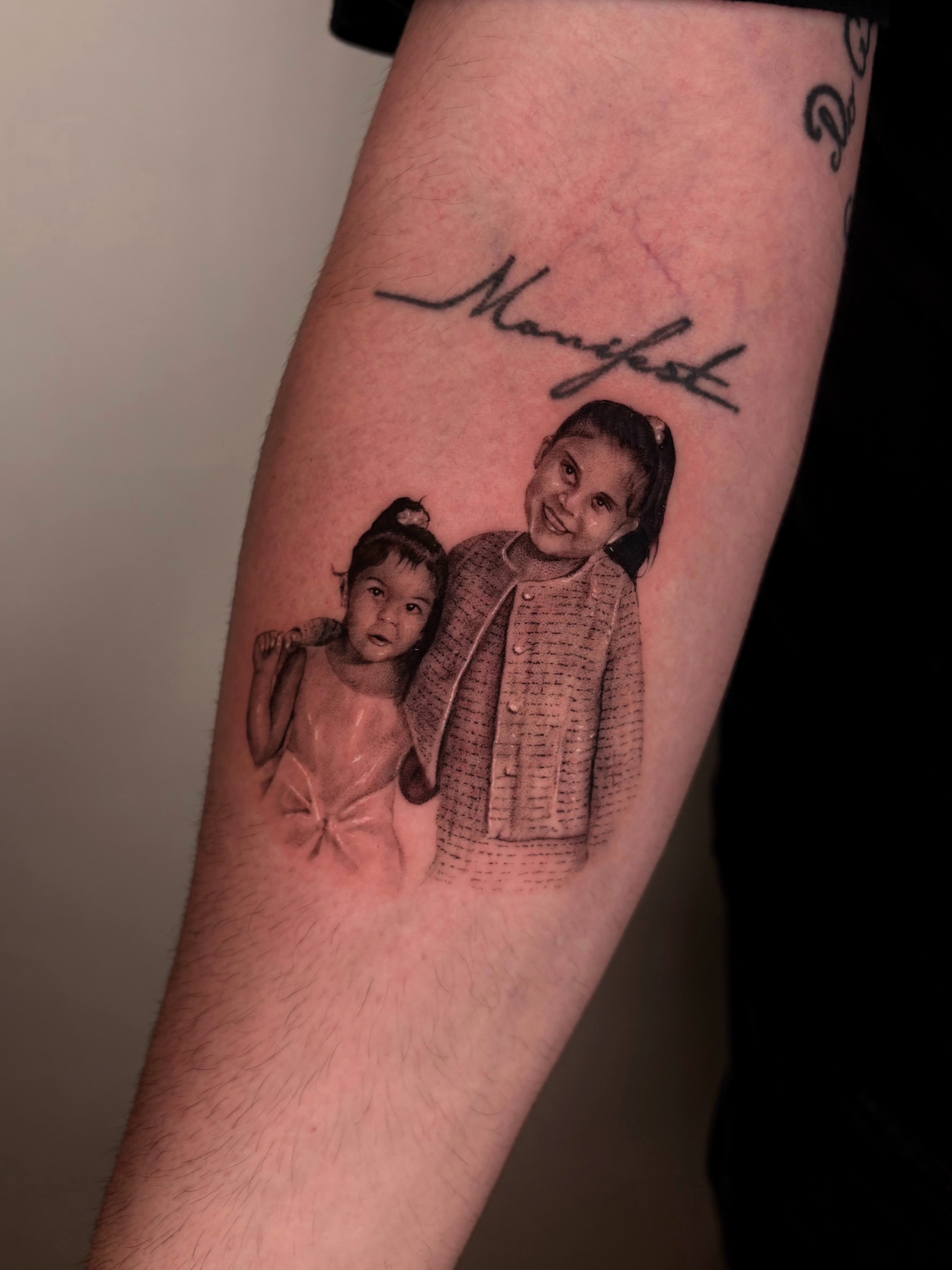 Portrait of two children realism tattoo on the forearm by Gabriel