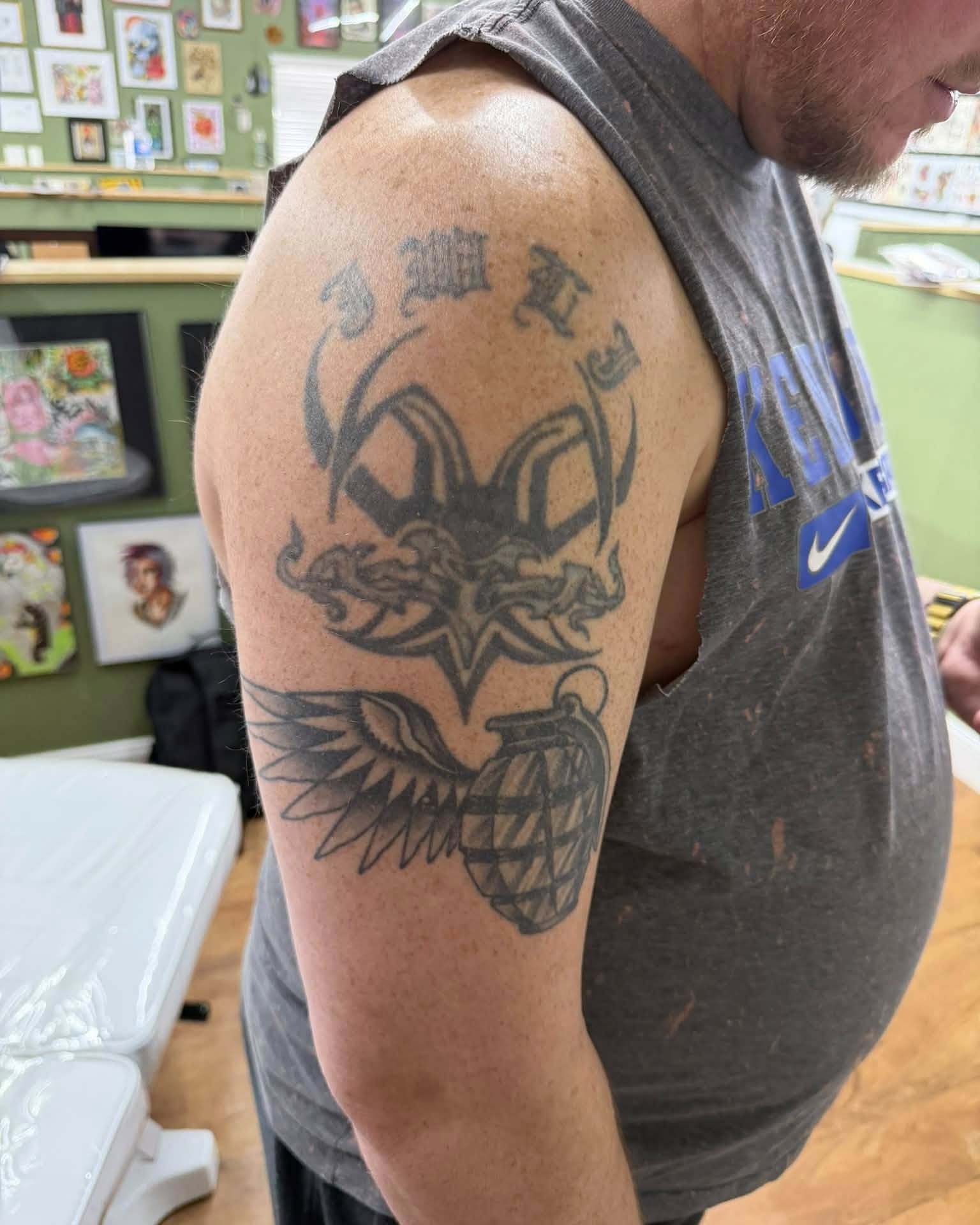 Winged grenade black and grey tattoo on the upper arm by Corey Bailey, Stanton, Kentucky