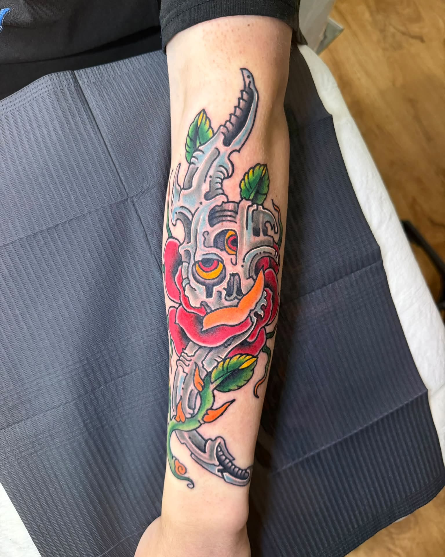 Mechanical skull with rose American traditional tattoo on the forearm by Corey Bailey, Stanton, Kentucky