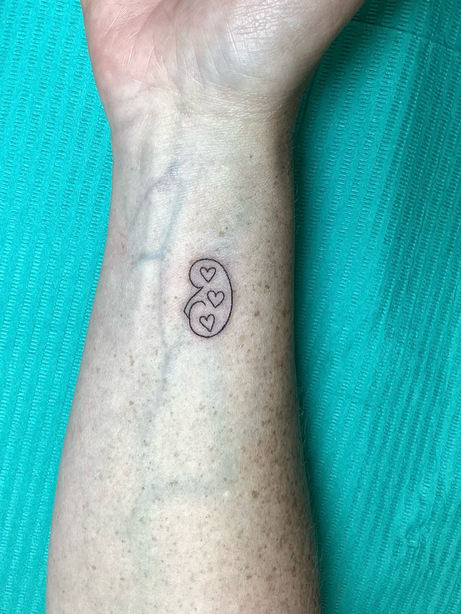 Kidney with hearts geometric tattoo on the forearm by Amanda Plavan