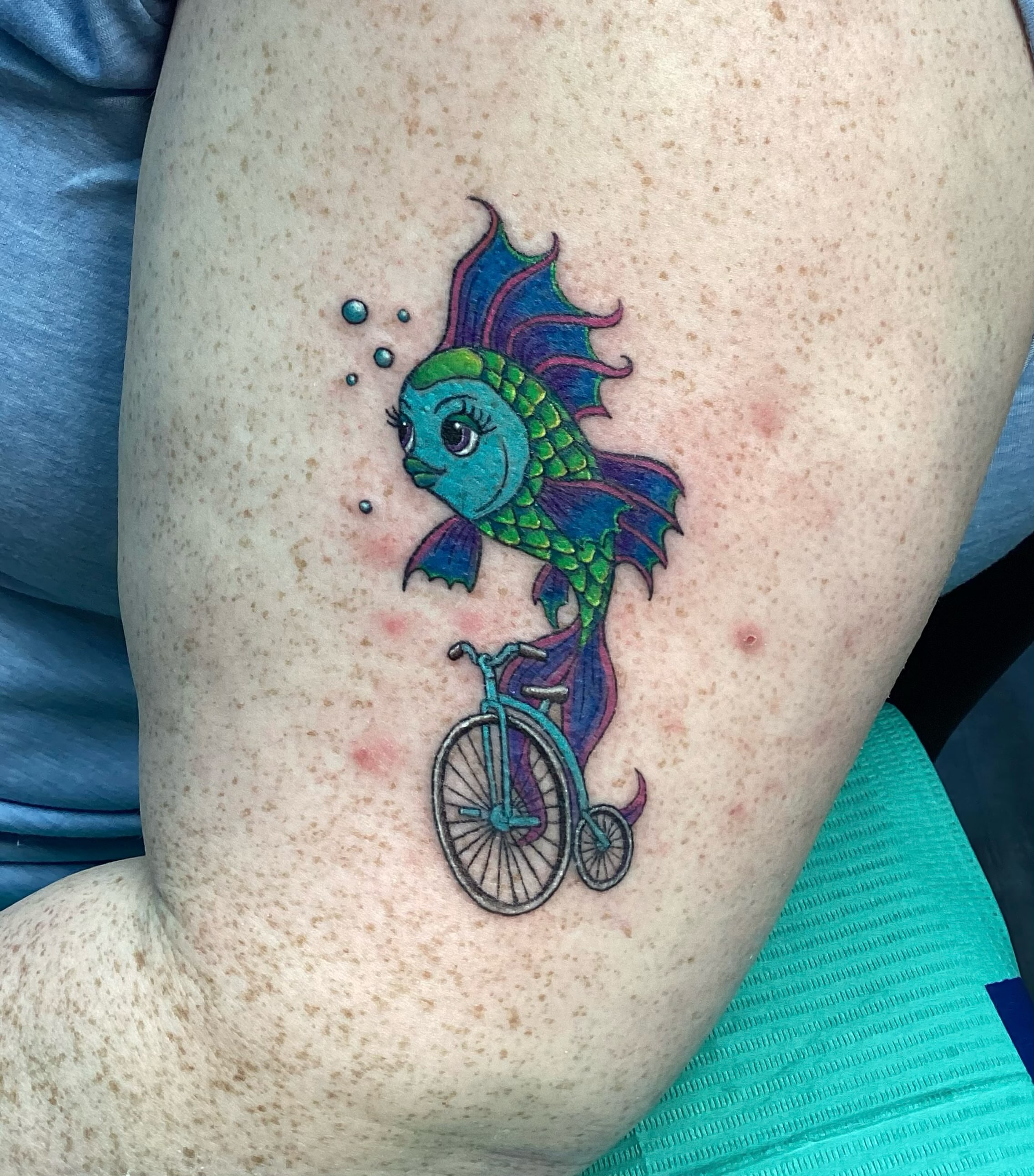 Fish riding bicycle new school tattoo on the thigh by Amanda Plavan