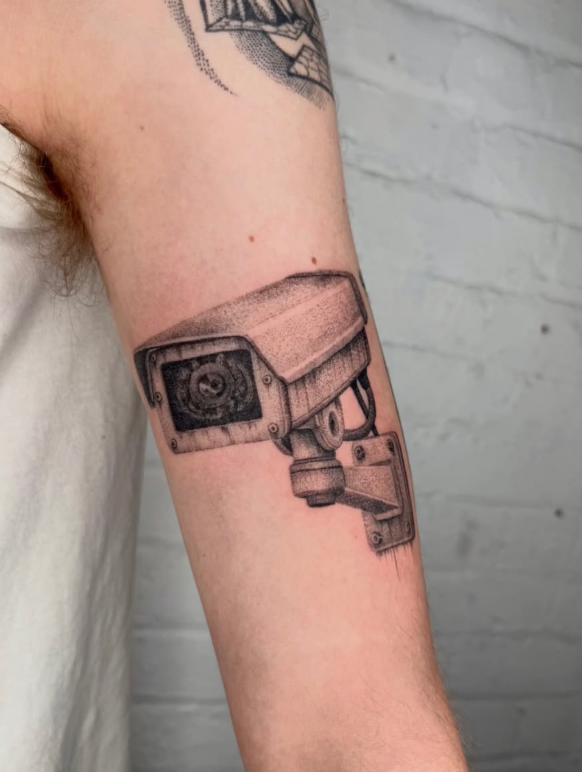 Security camera dotwork tattoo on the forearm by Kenny ๐ด