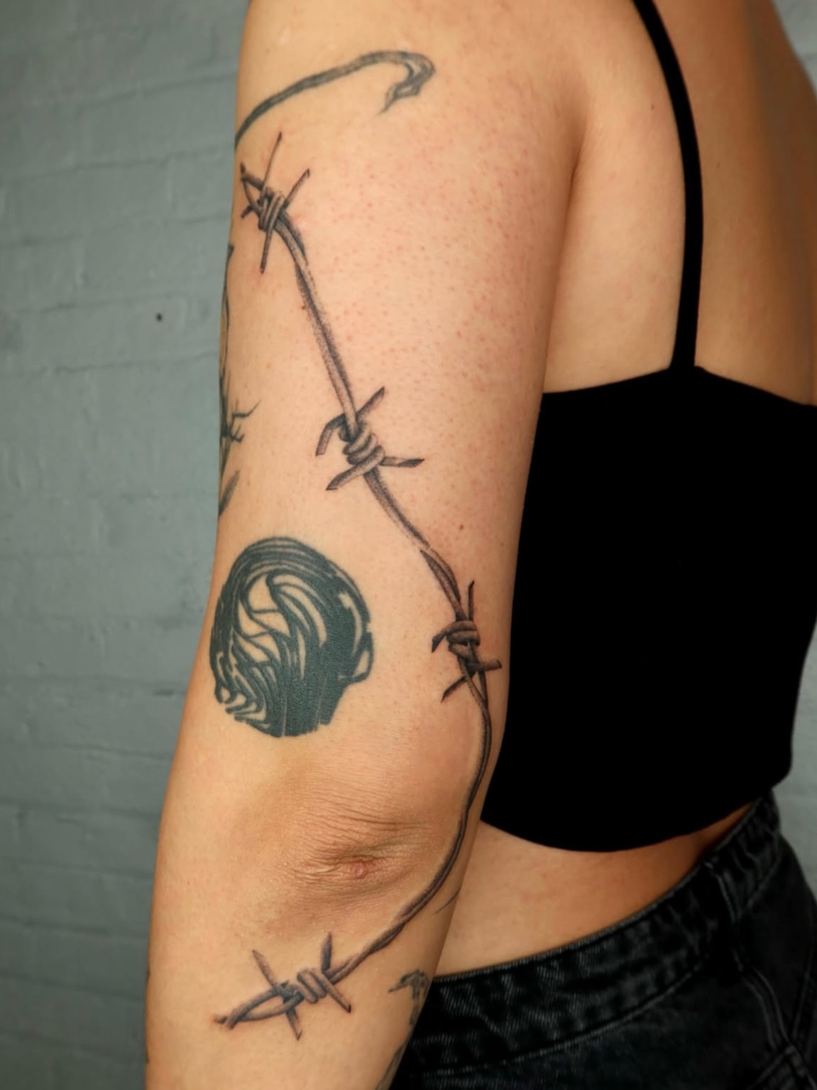 Barbed wire black and grey tattoo on the forearm by Kenny ๐ด