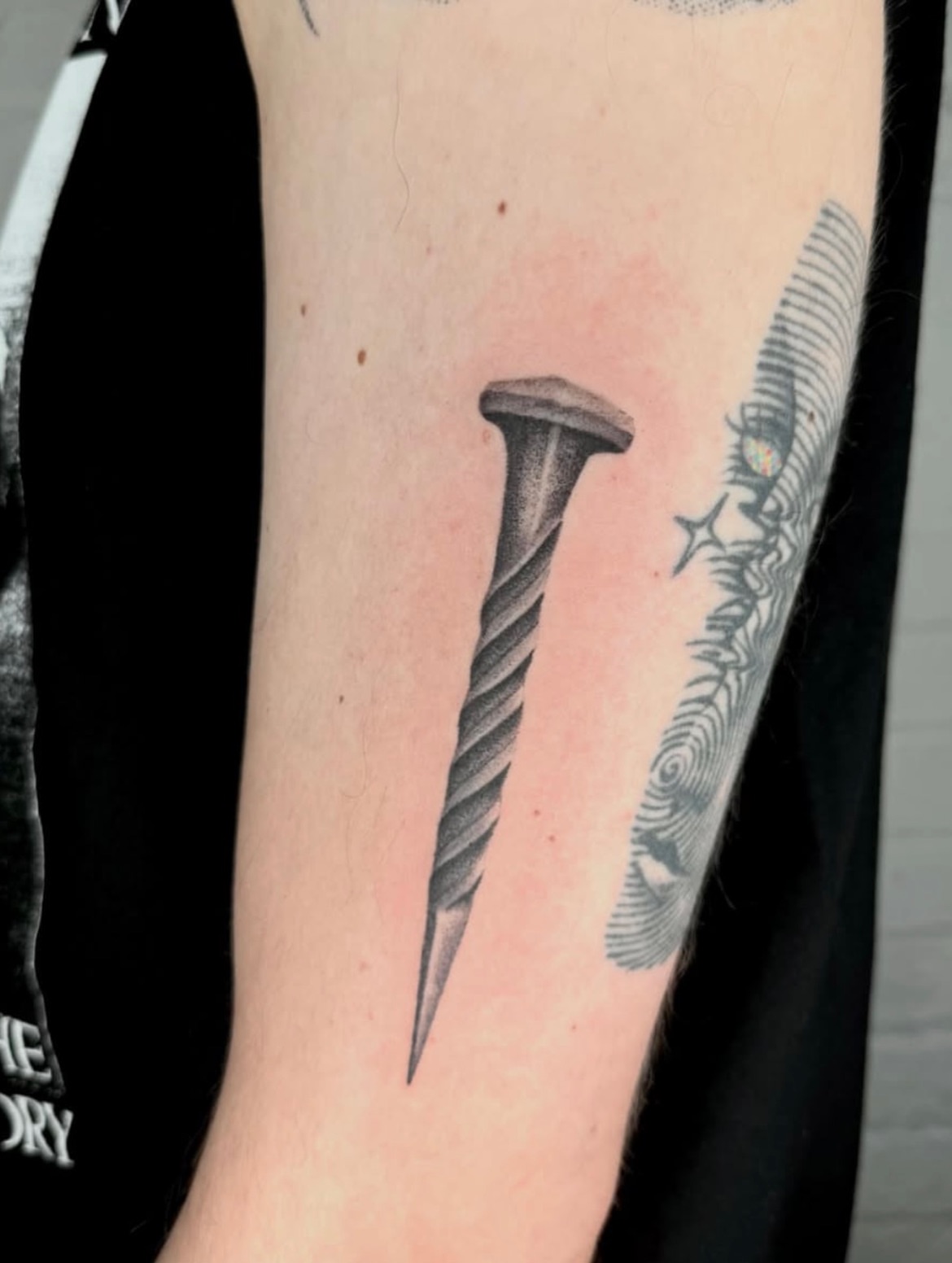 Nail black and grey tattoo on the forearm by Kenny ๐ด