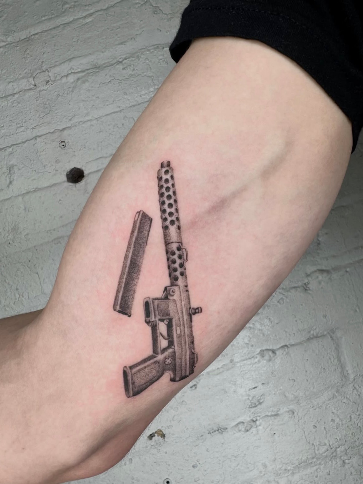 Machine gun realism tattoo on the forearm by Kenny ๐ด