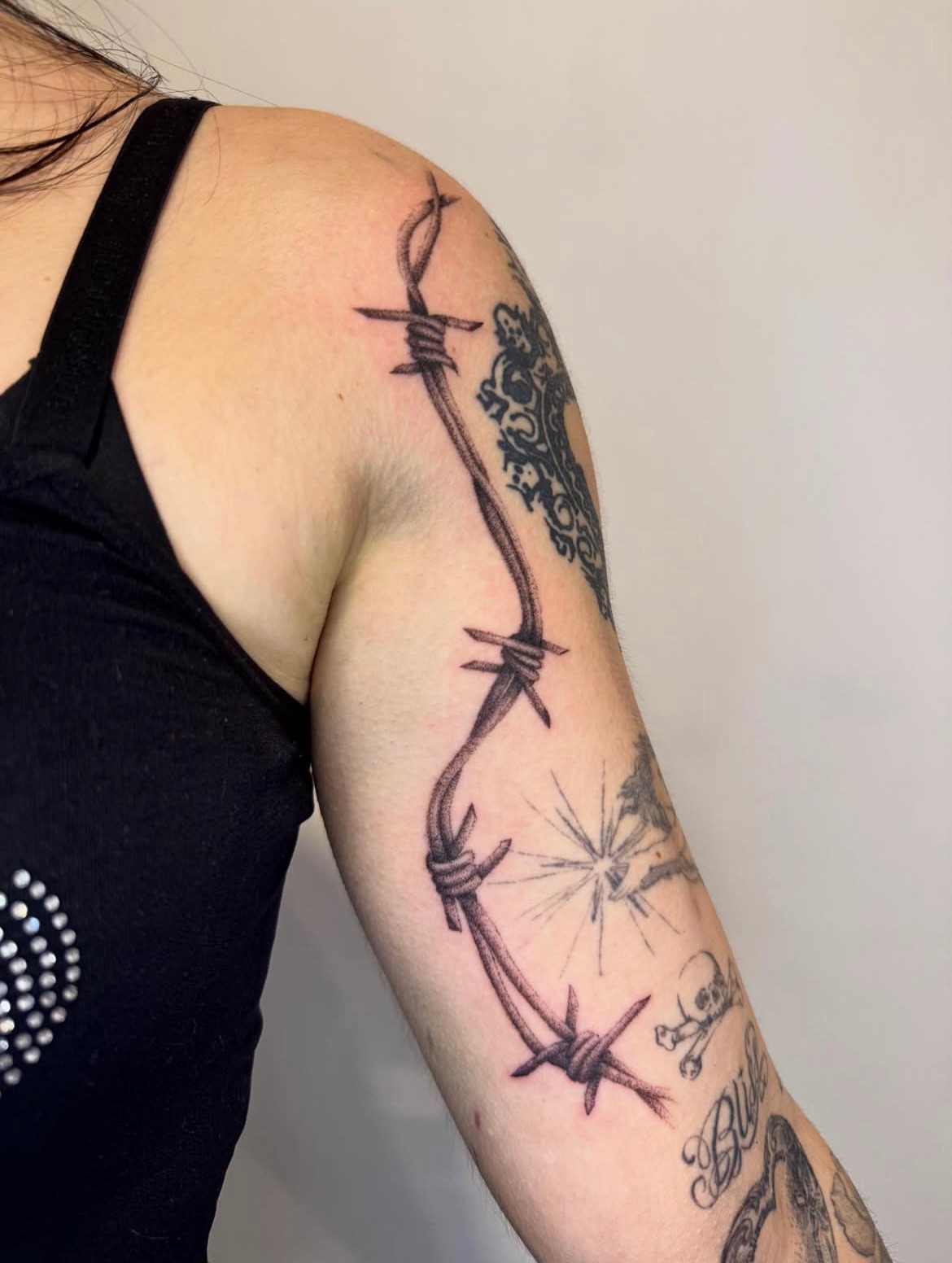 Barbed wire and skull black and grey tattoo on the forearm by Kenny ๐ด