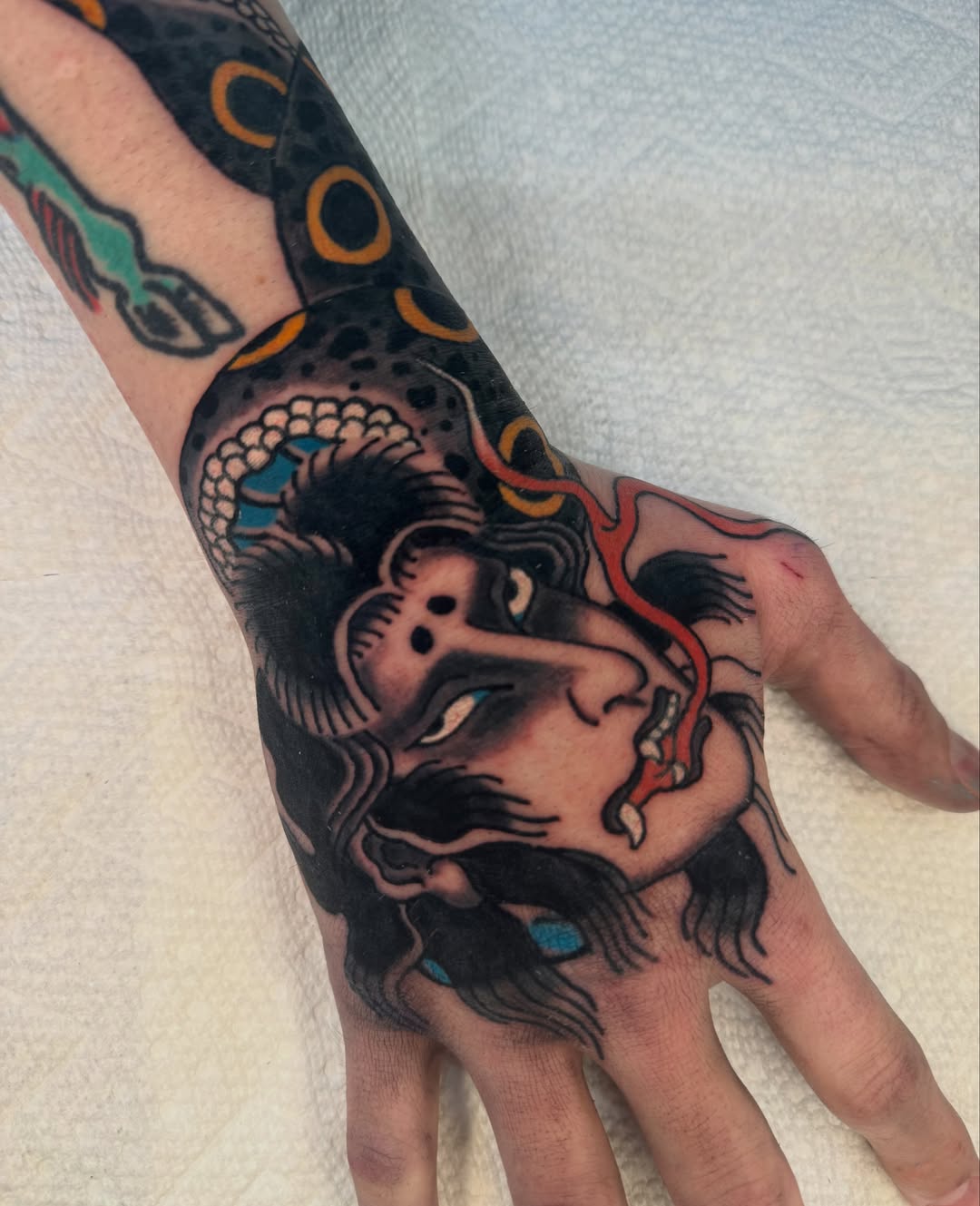 Man's face American traditional tattoo on the hand by Mr Nikita, New York, New York