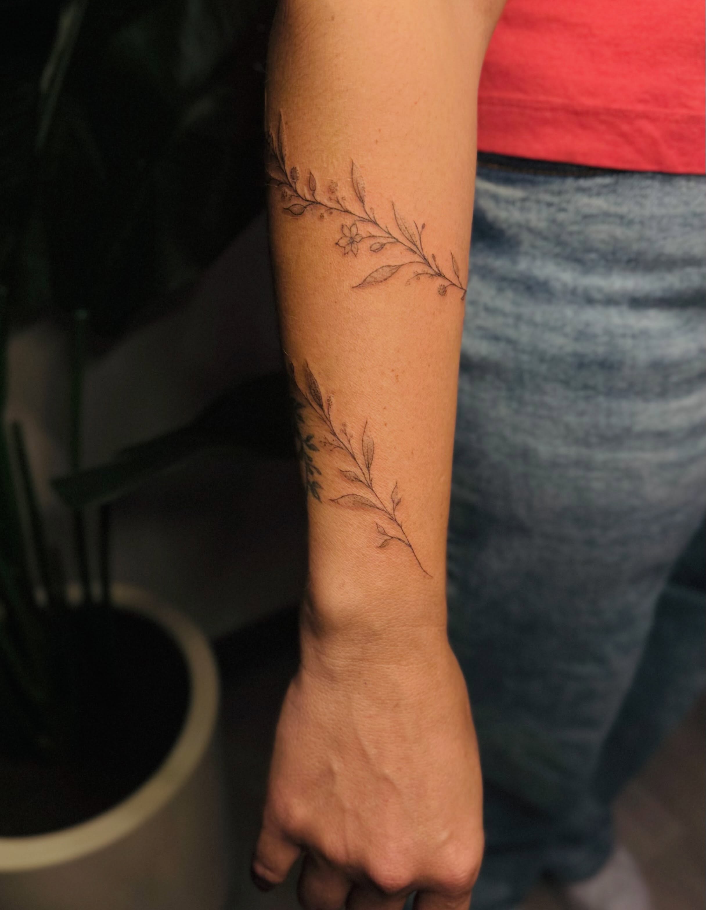 Branch with leaves fine line tattoo on the forearm by Ashley Pilgreen