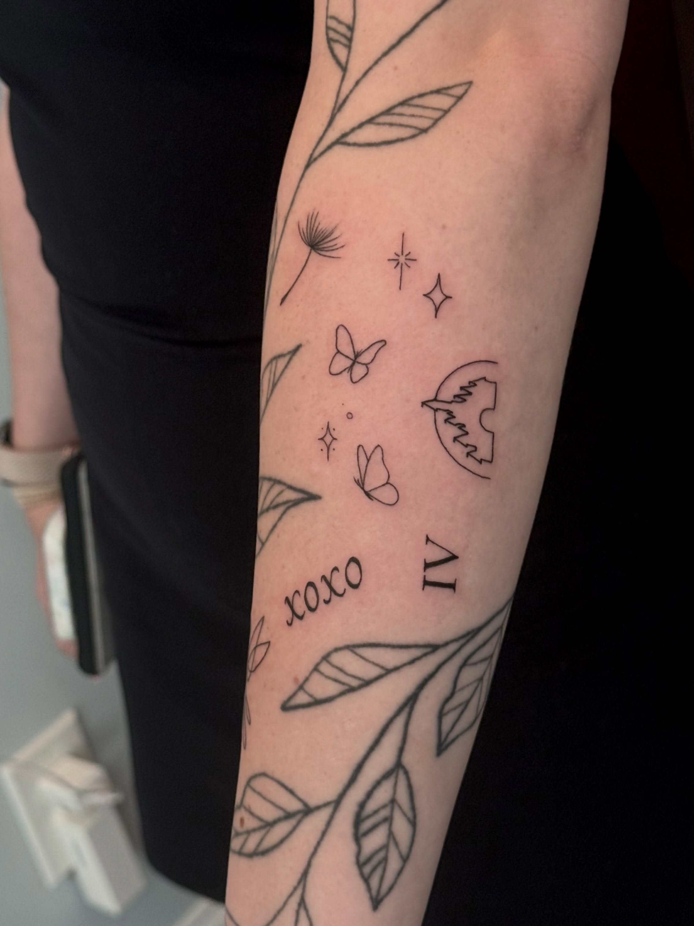 Floral and celestial motifs fine line tattoo on the forearm by Ana Blatt