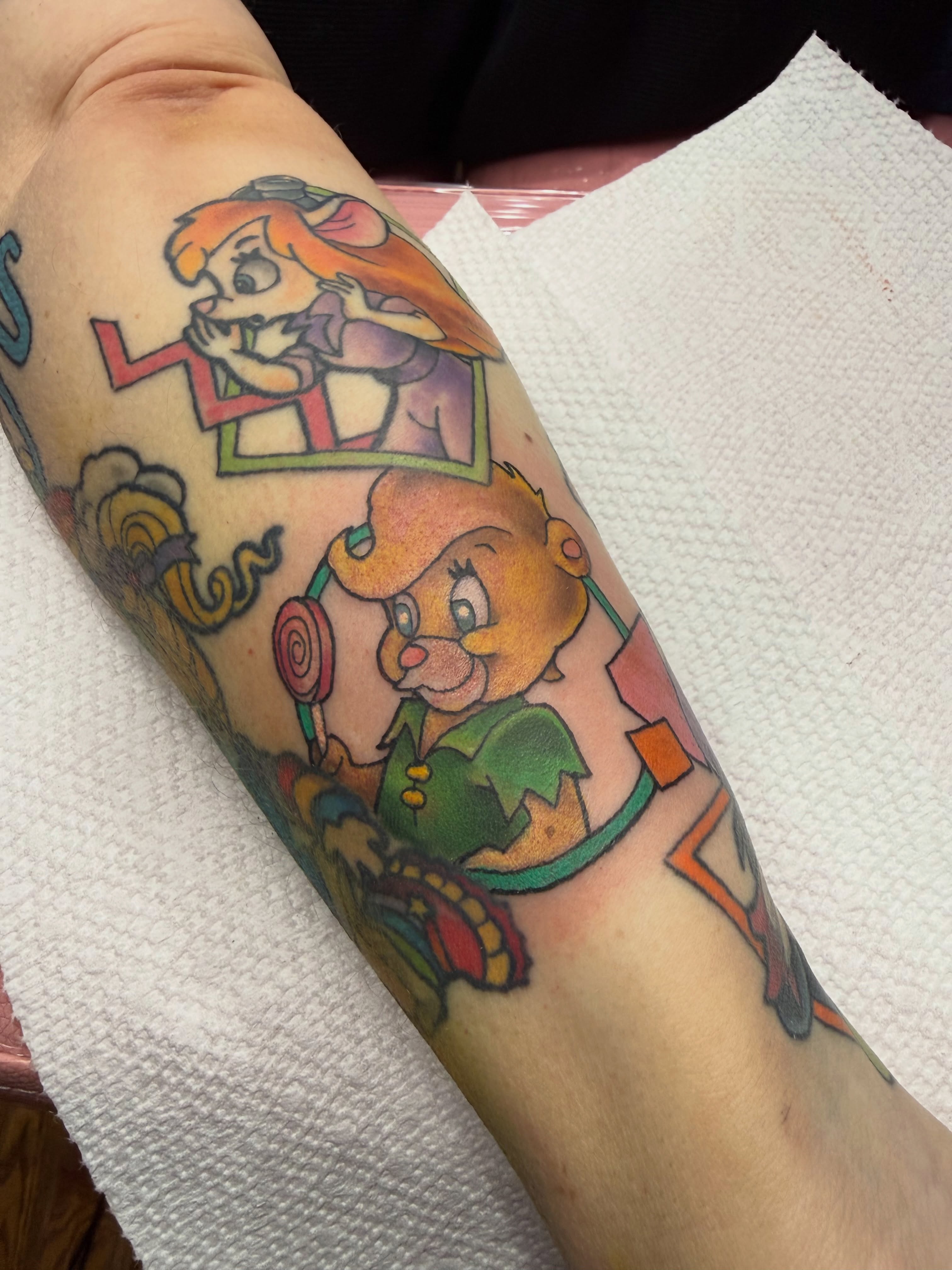 Alice and cheshire cat American traditional tattoo on the forearm by Erin Peterson