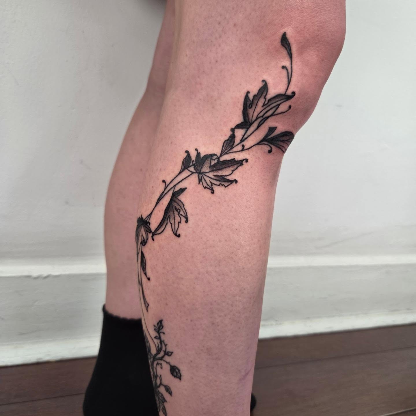 Flower branch black and grey tattoo on the leg by Payton