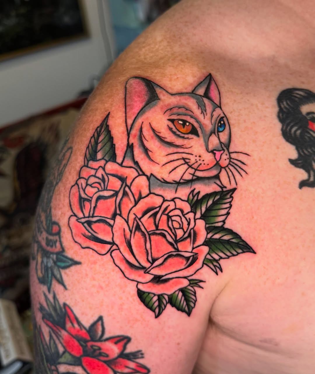 Cat and roses American traditional tattoo on the shoulder by @michaelryan_tattoo