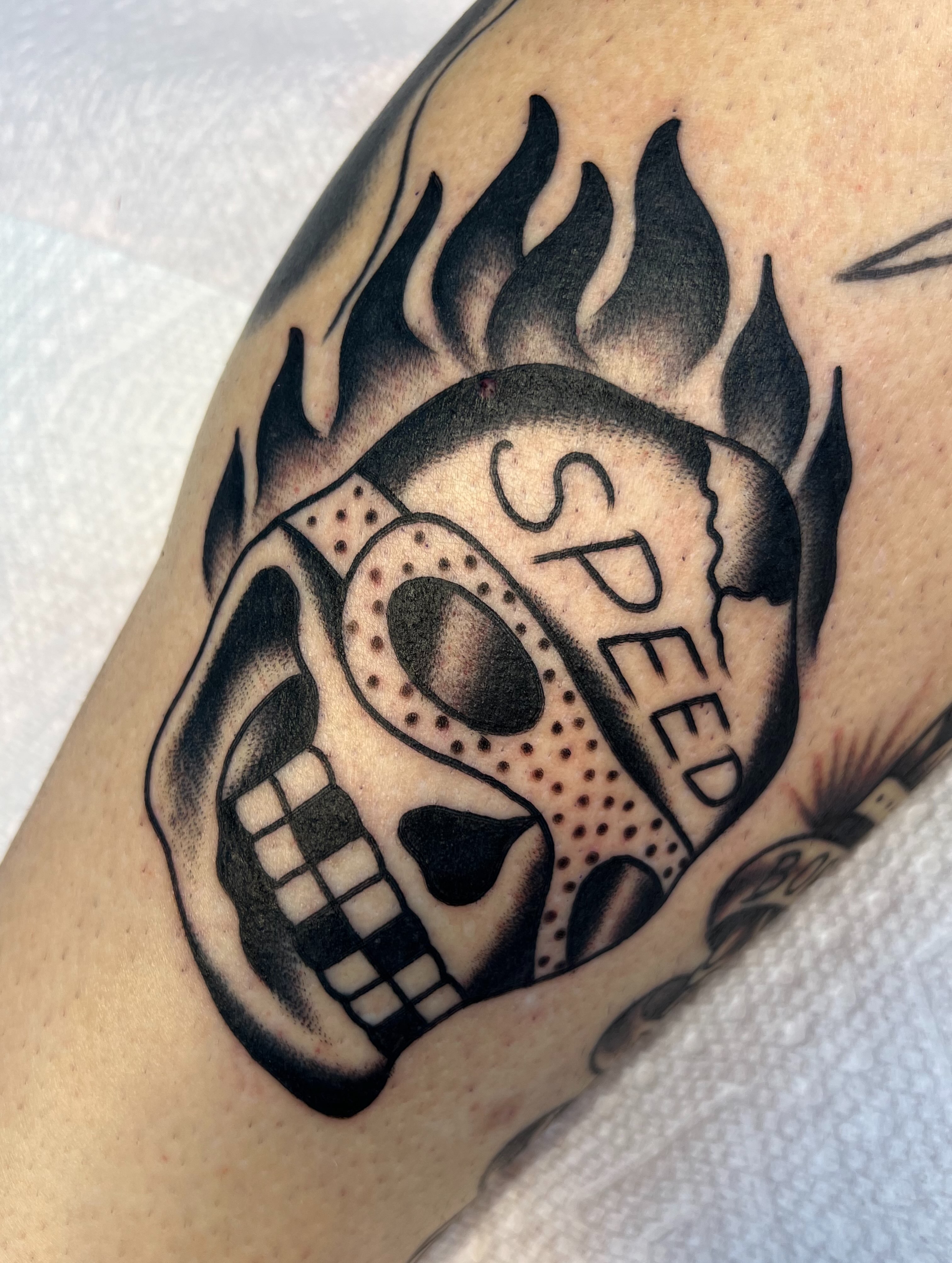 Skull with flame American traditional tattoo on the forearm by Zach Roman, Madison, Wisconsin