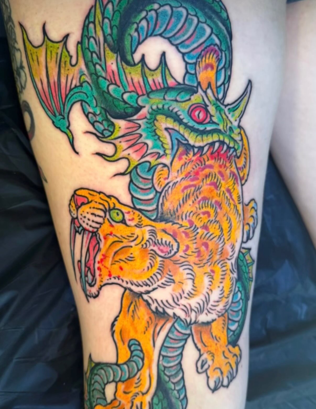 Dragon and tiger American traditional tattoo on the thigh by Tim Lehi, Oakland, California