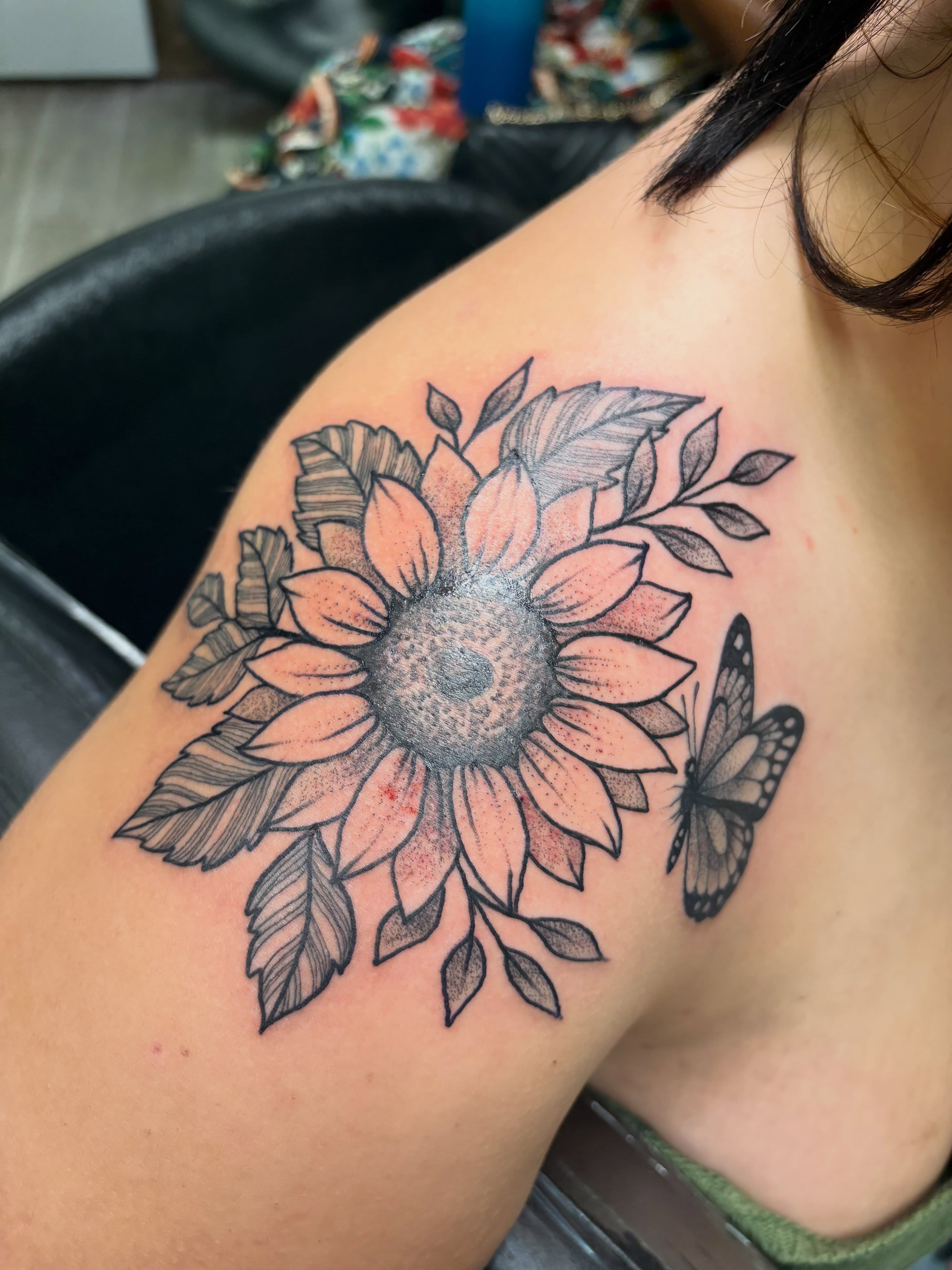 Sunflower and butterfly dotwork tattoo on the shoulder by Julie Bird