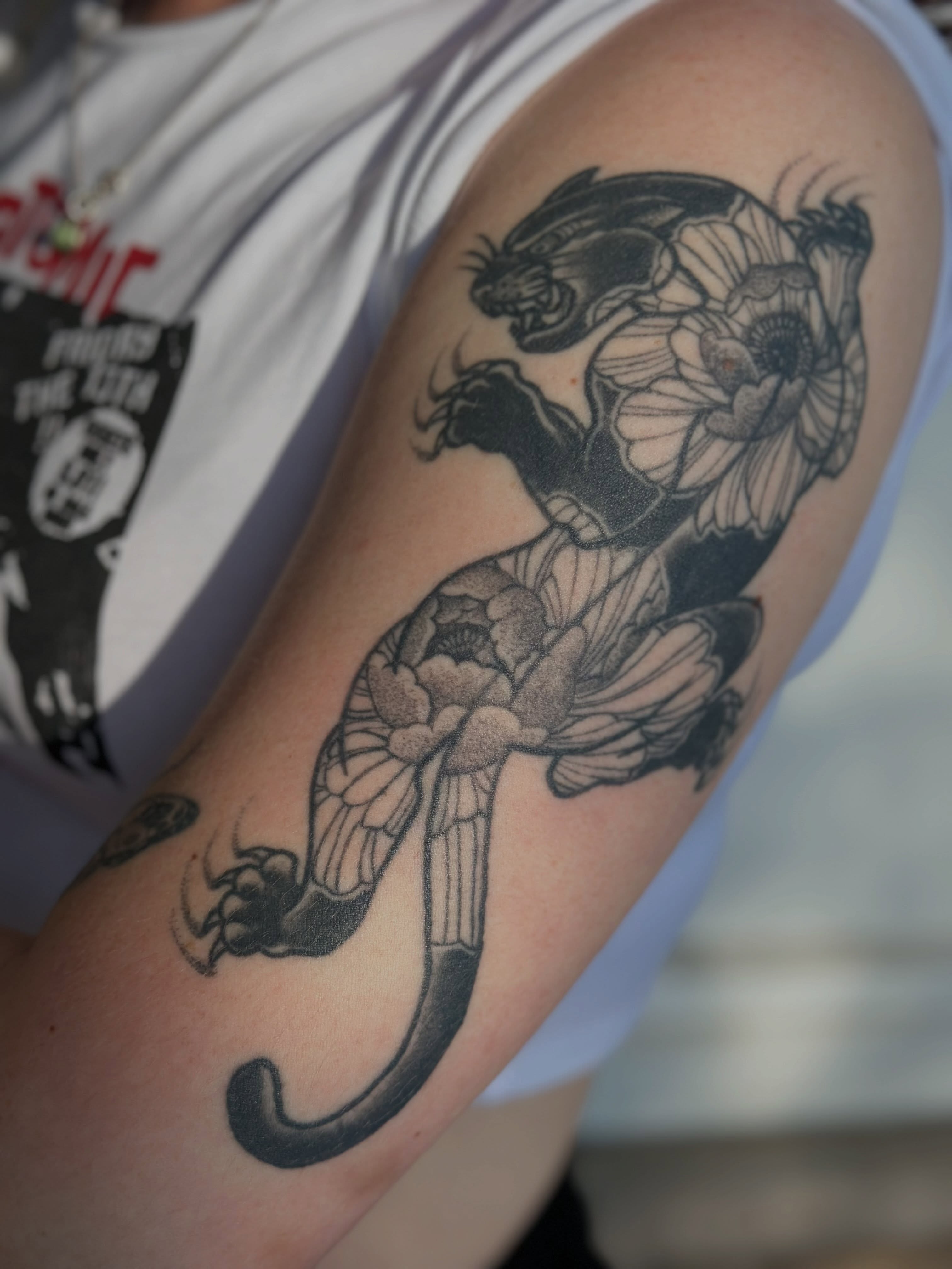Panther and flowers black and grey tattoo on the forearm by Julie Bird