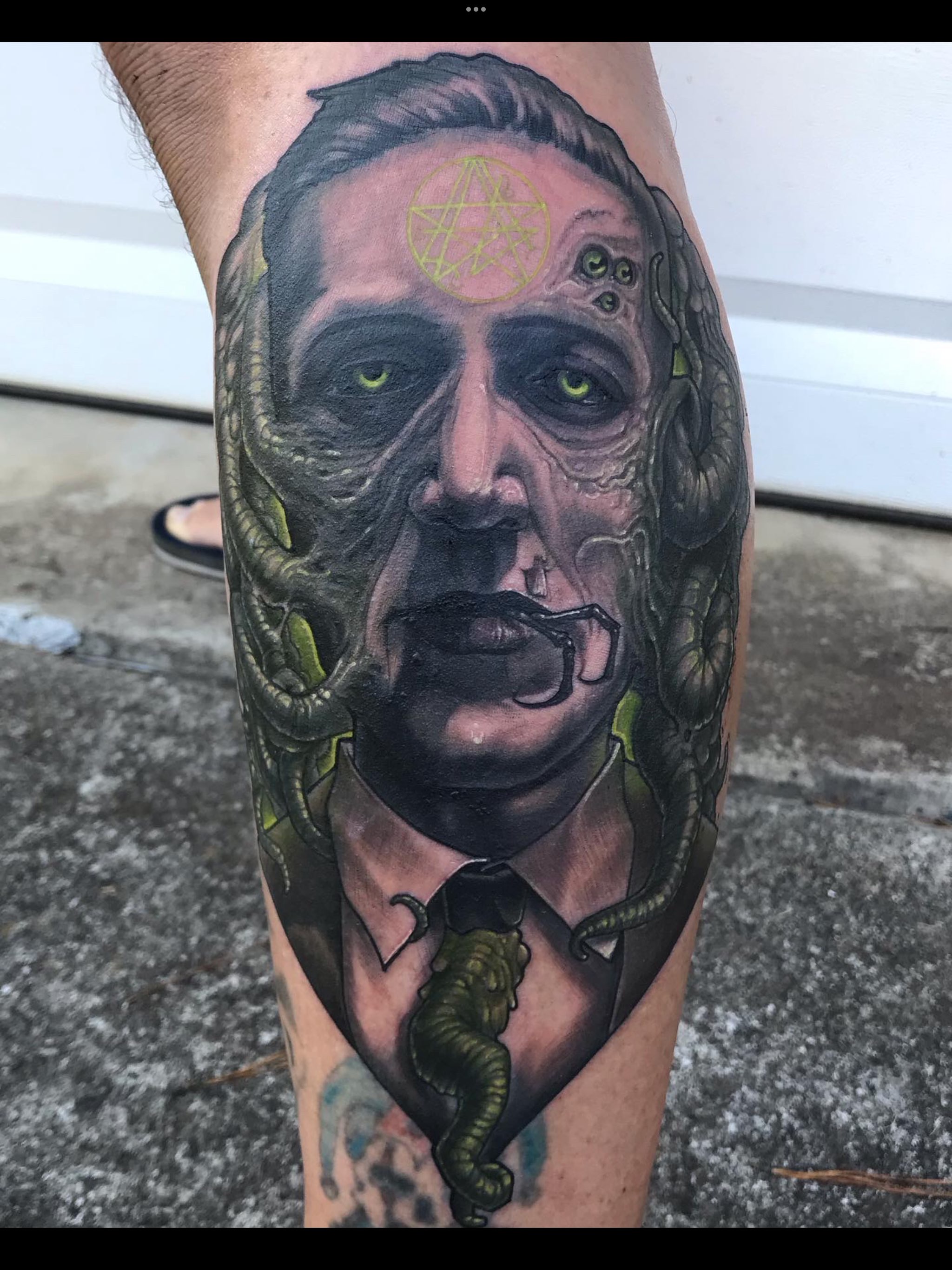 Man with surrealistic features dark realism tattoo on the forearm by Rick Rayne