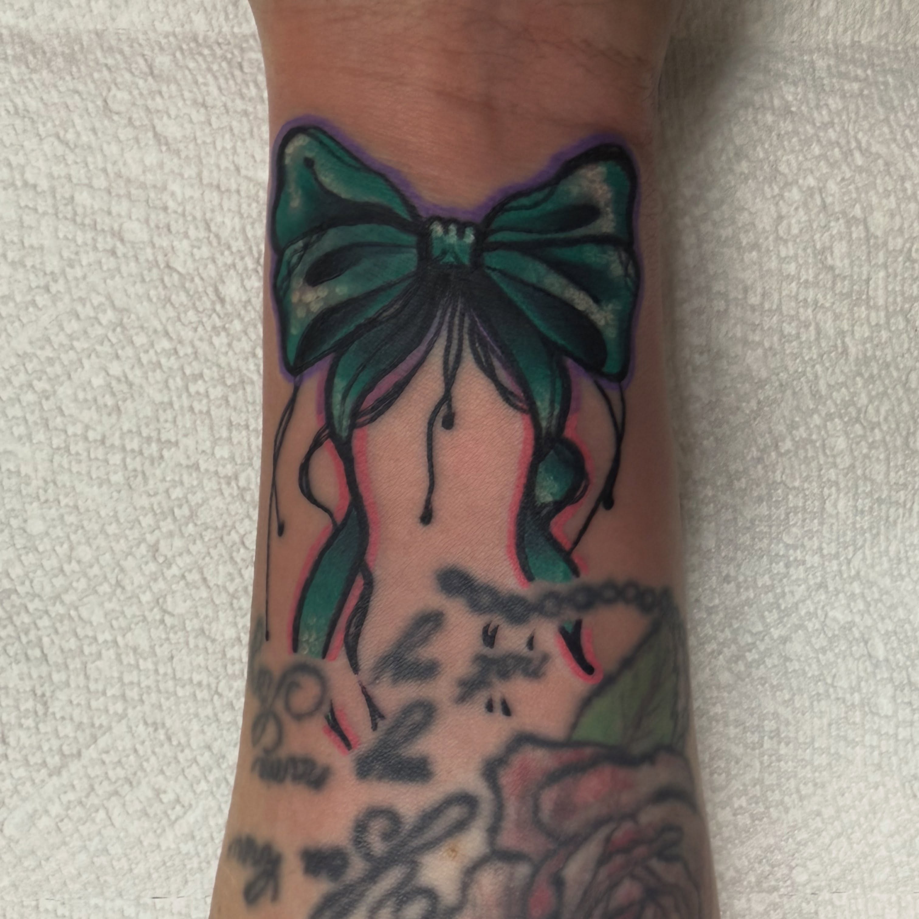 Bow and corset American traditional tattoo on the forearm by Will Eagle