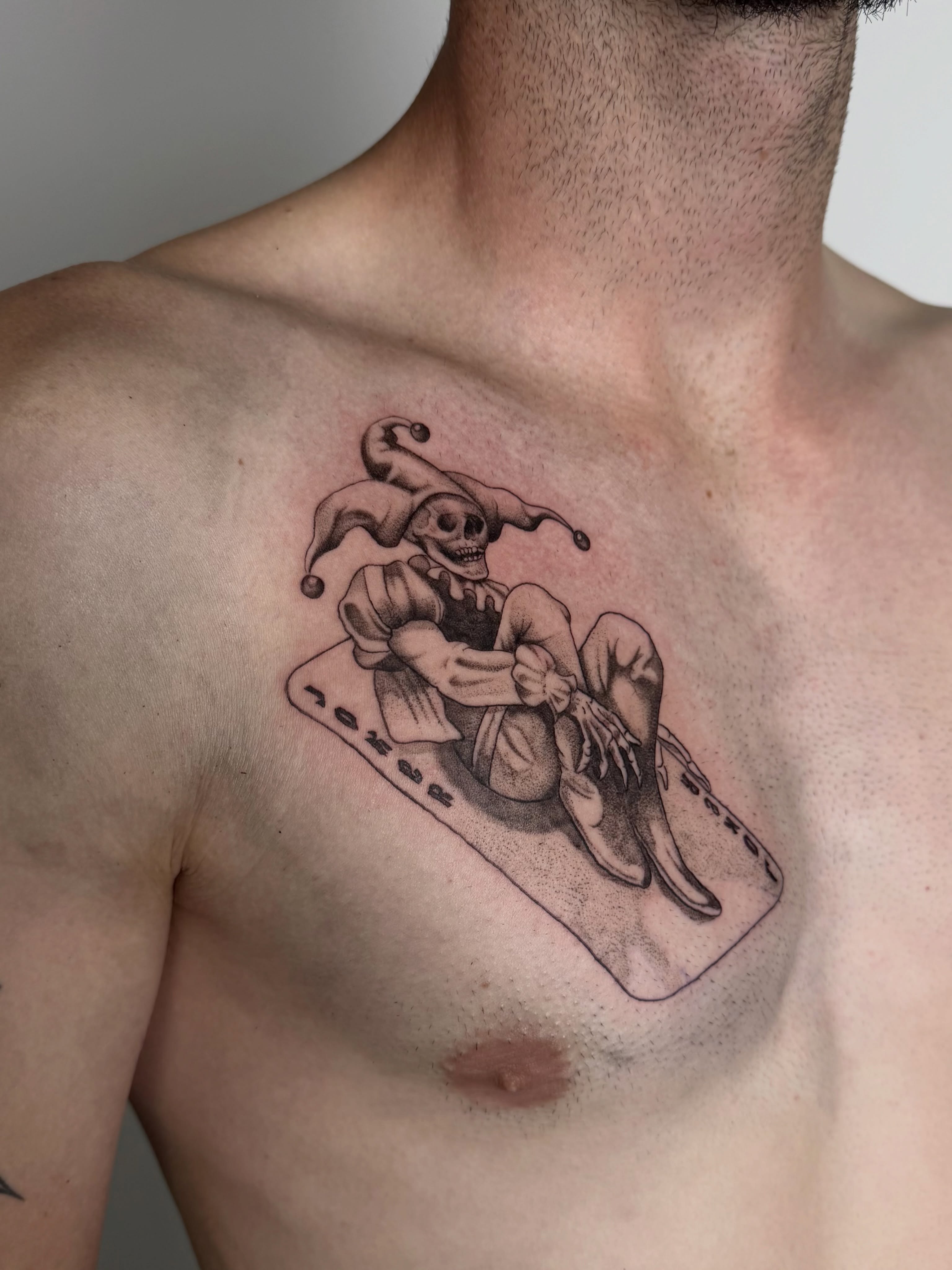 Jester skeleton black and grey tattoo on the chest by Bailee