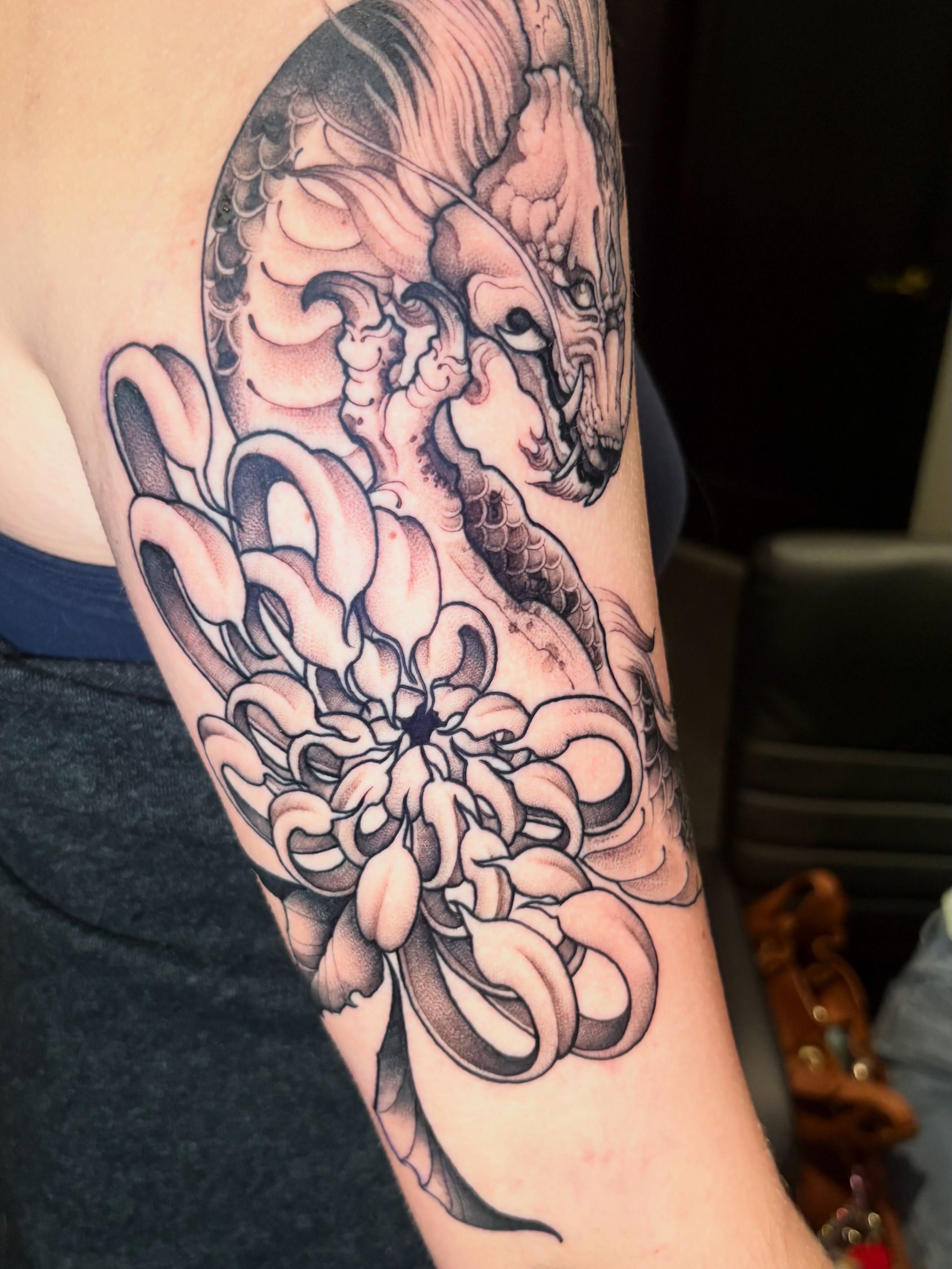 Dragon and chrysanthemum japanese irezumi tattoo on the forearm by Eddie Wolfe