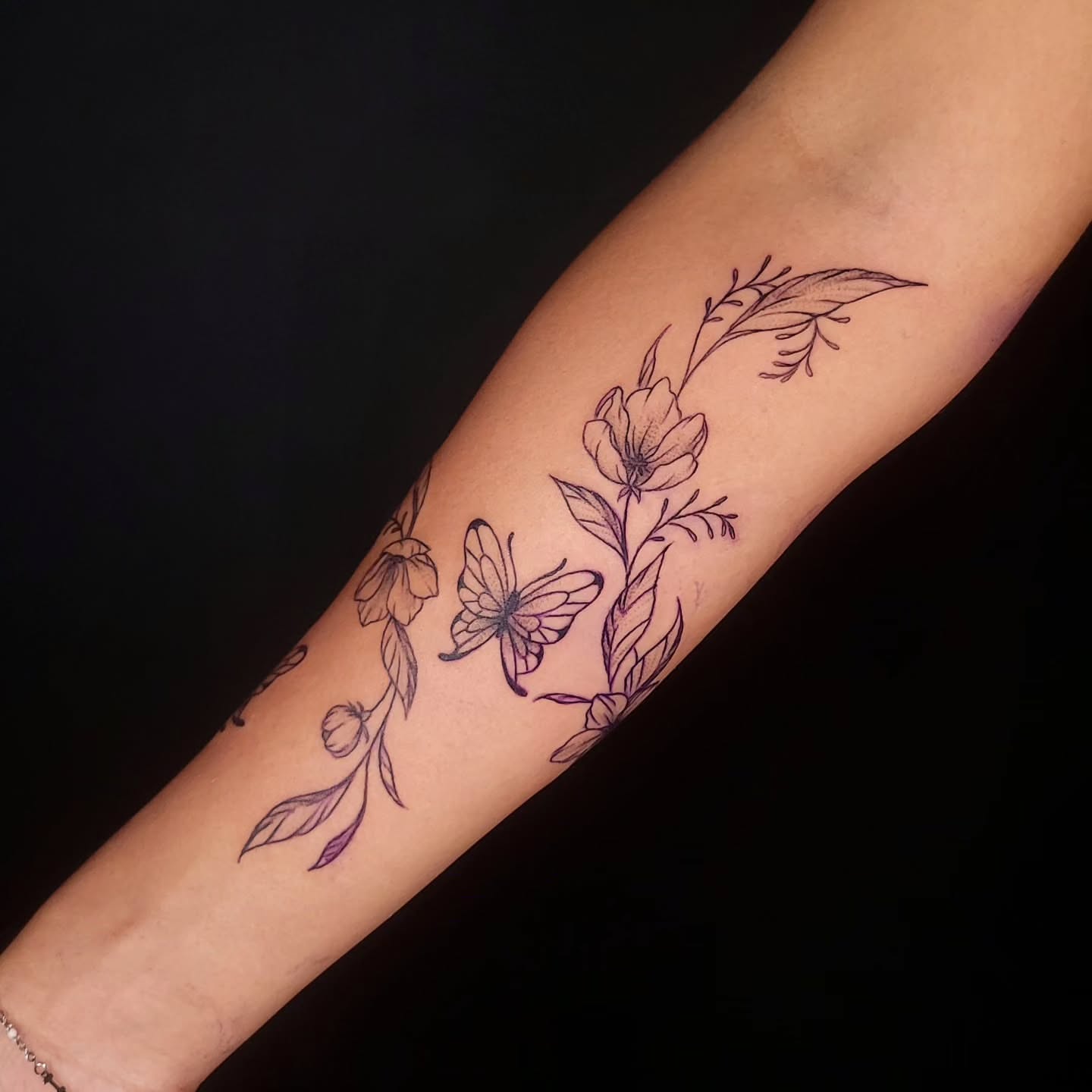 Butterfly and flowers black and grey tattoo on the forearm by Sarah Alba