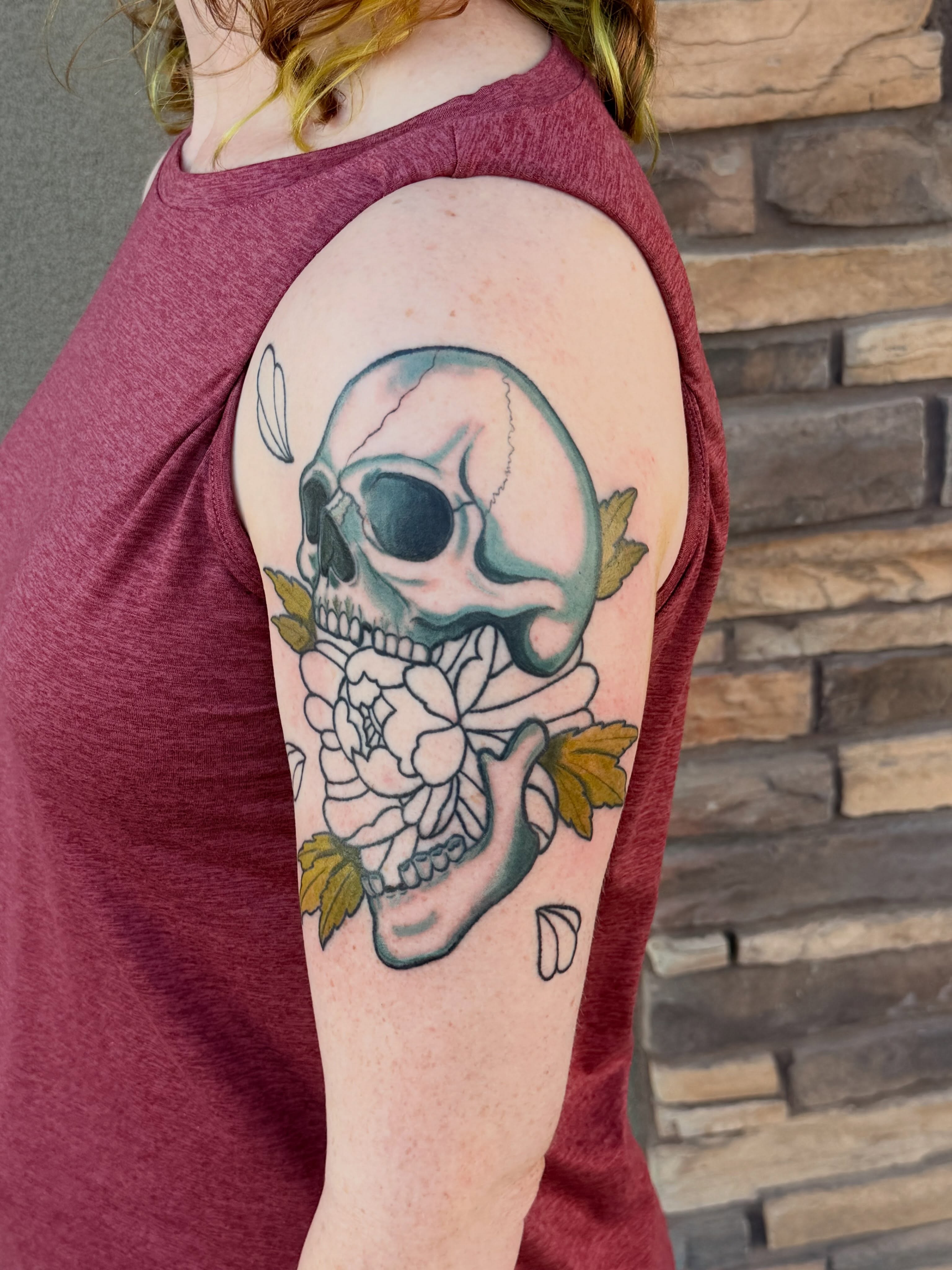 Skull and flowers American traditional tattoo on the shoulder by Ellari