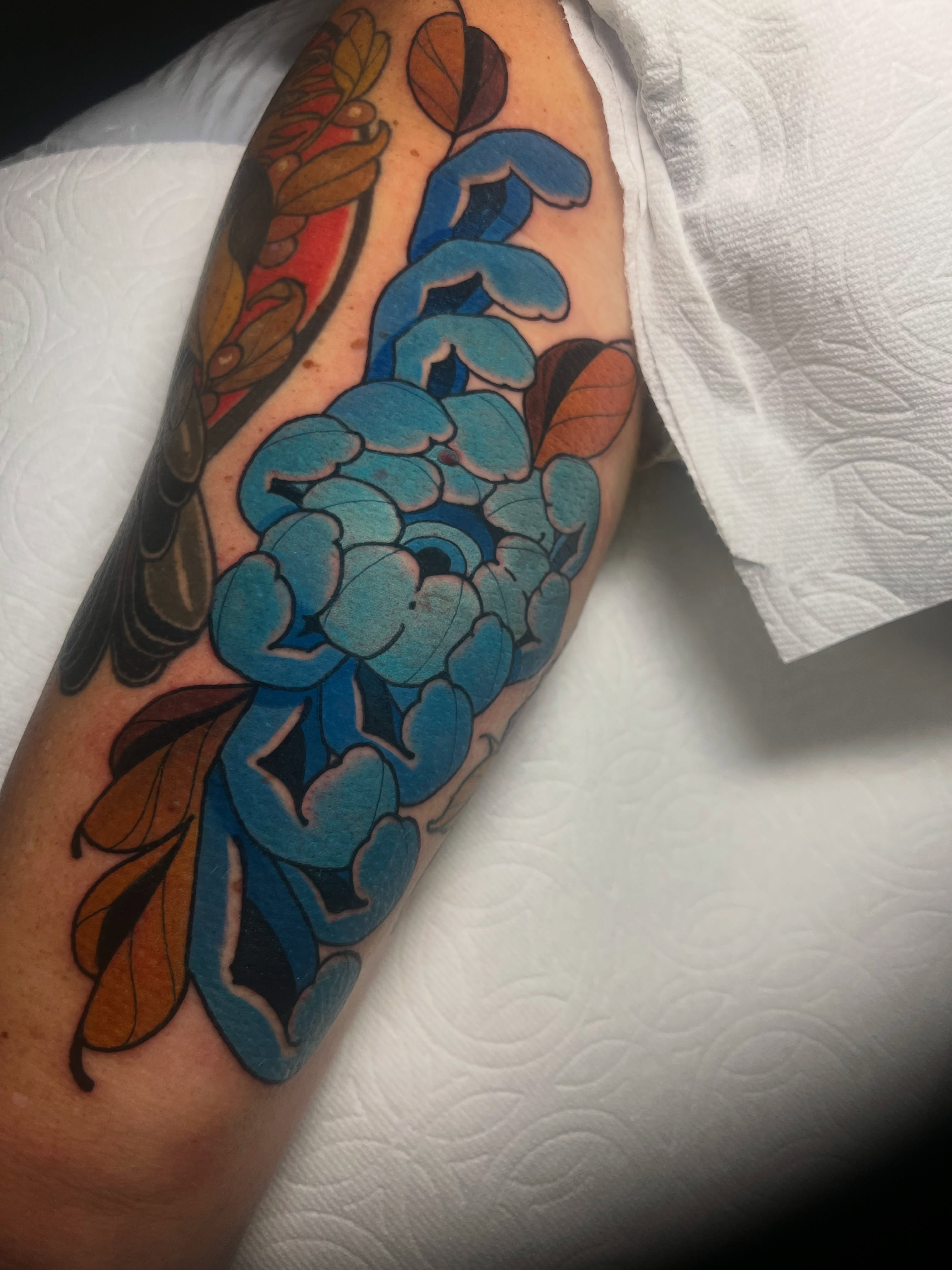 Blue flower American traditional tattoo on the forearm by Rennie Tattoo