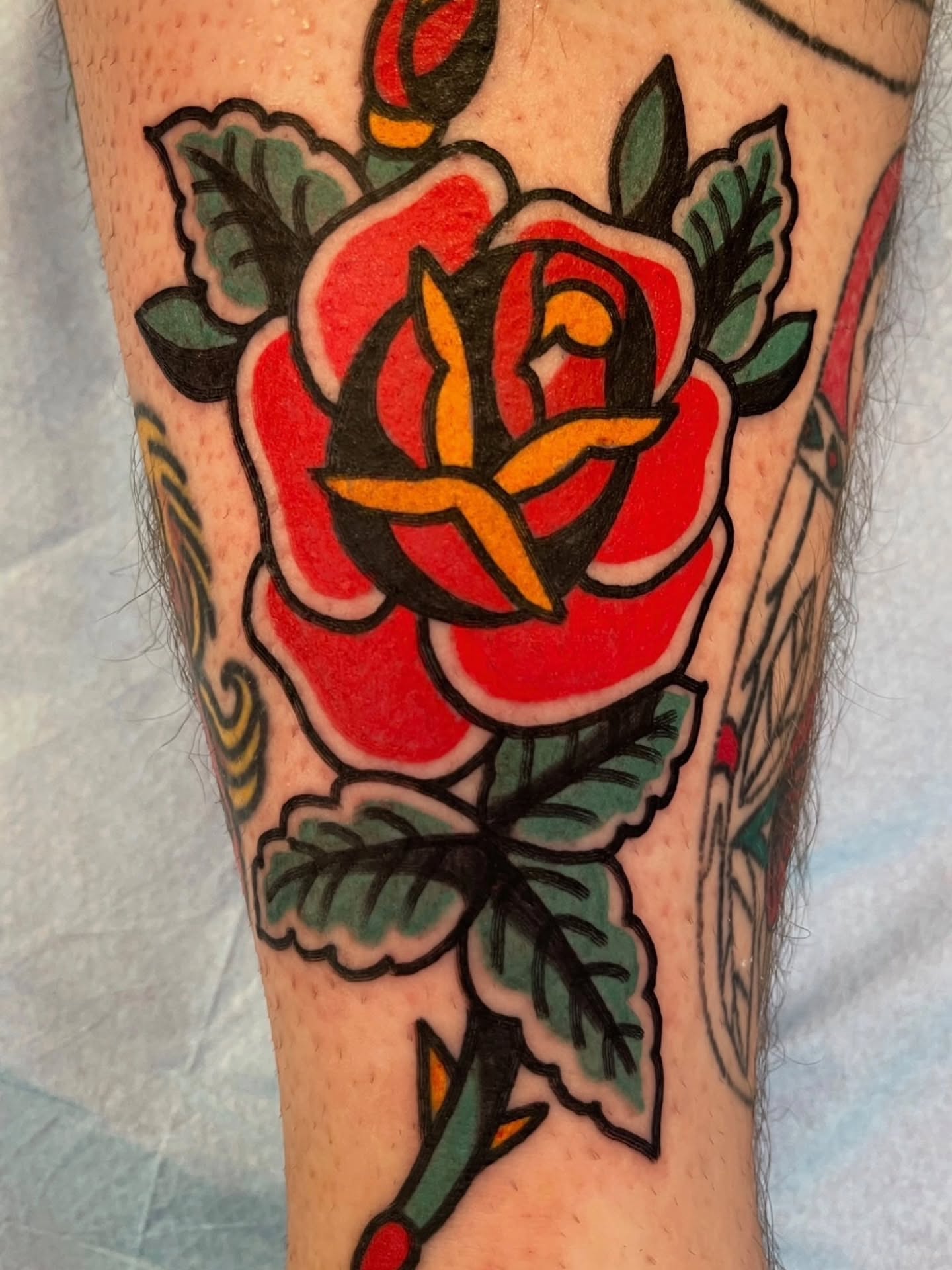 Red rose American traditional tattoo on the forearm by Don Lee