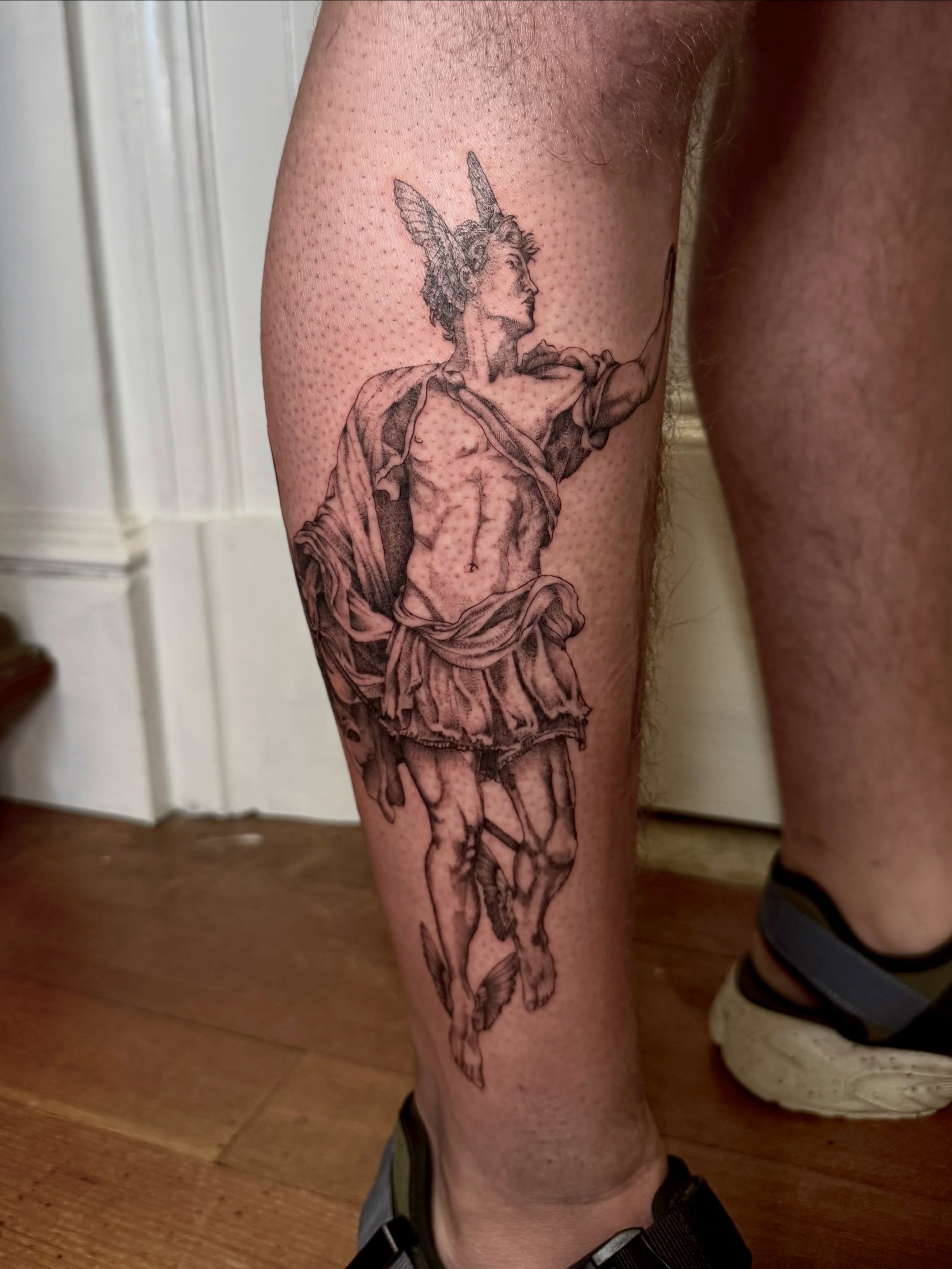Statue of a warrior realism tattoo on the calf by Ian Saner