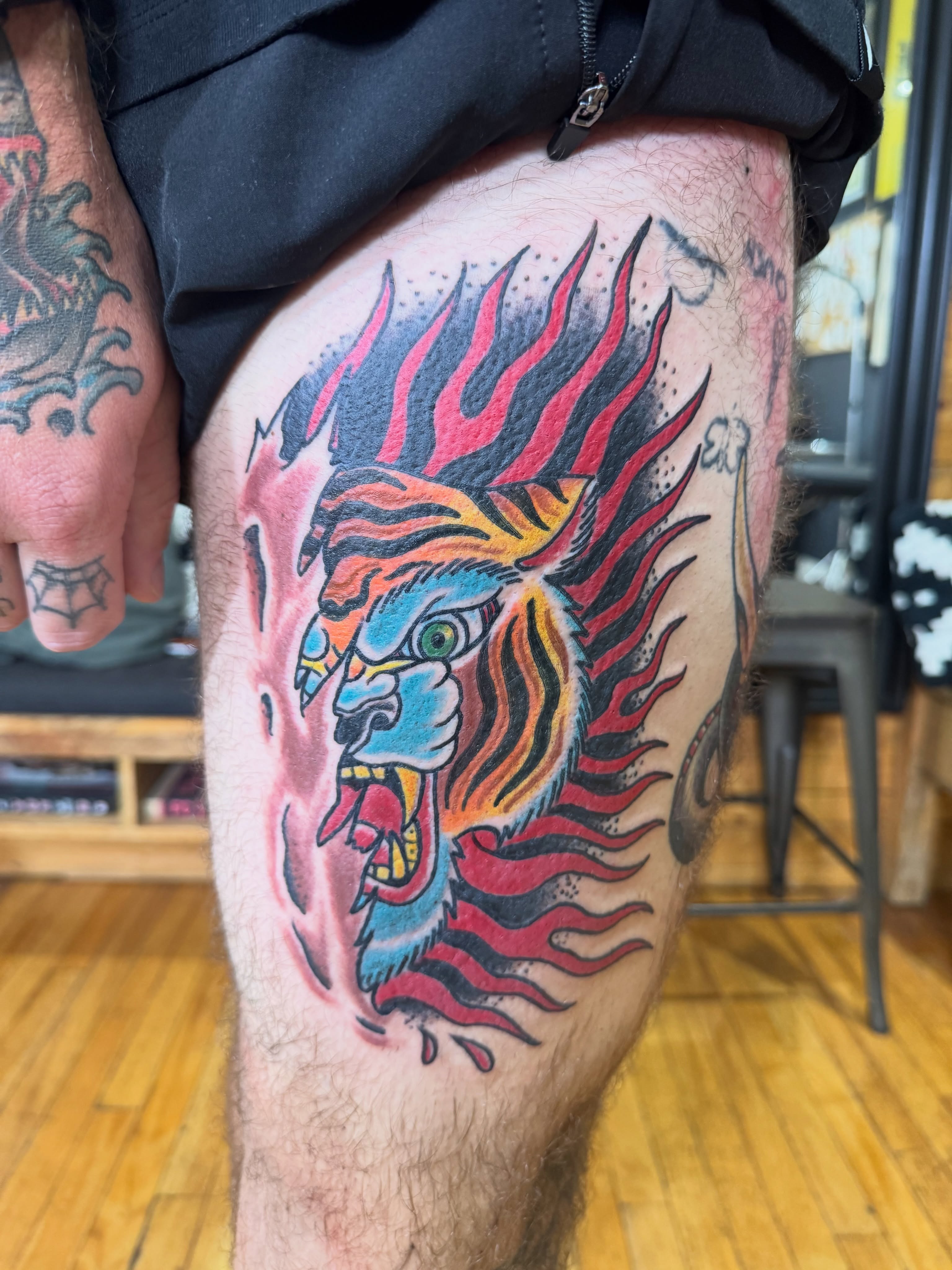 Flaming lion American traditional tattoo on the thigh by Eric James, Columbus, Ohio