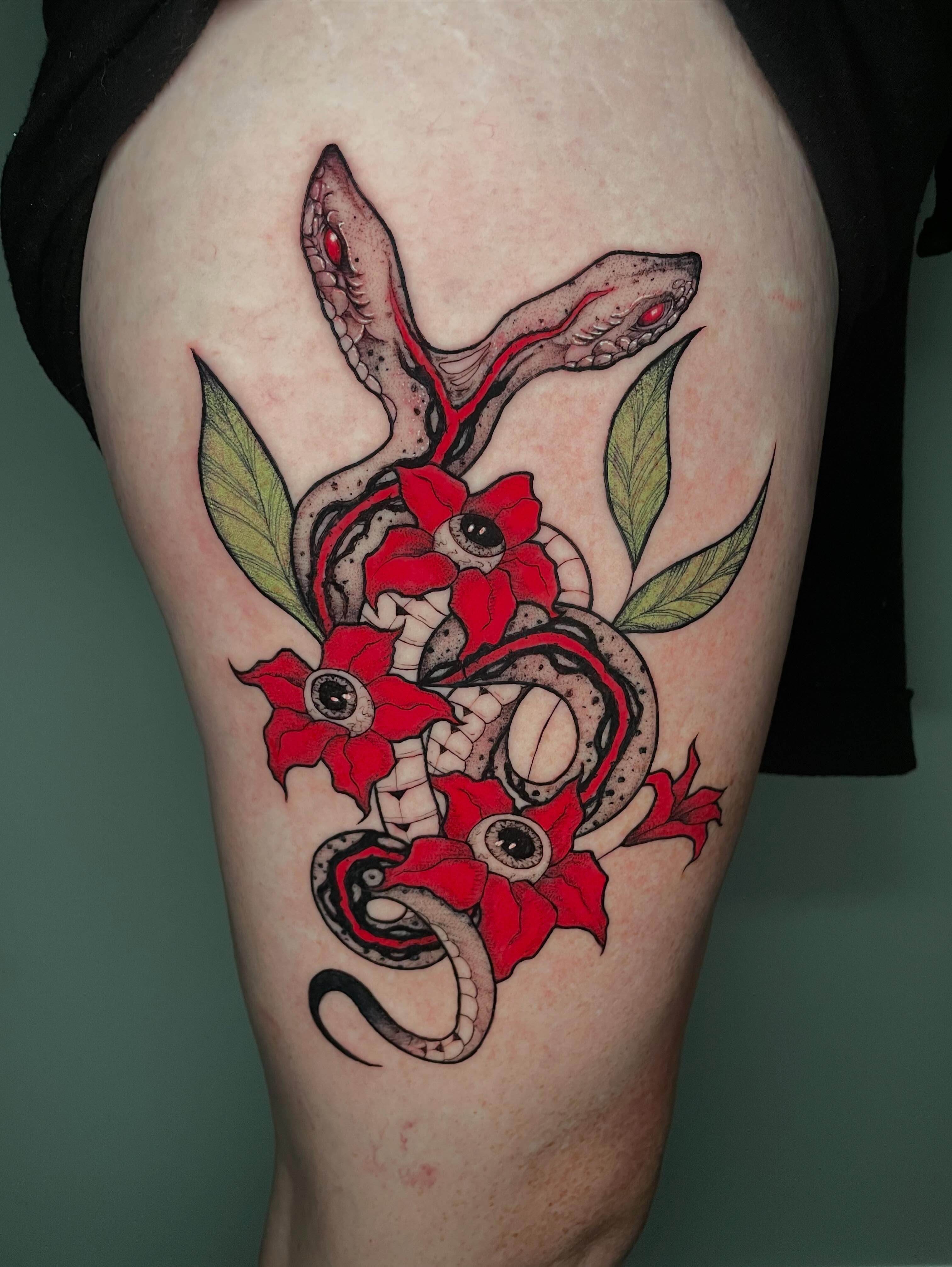 Snake and flowers American traditional tattoo on the thigh by Shontel Fowler