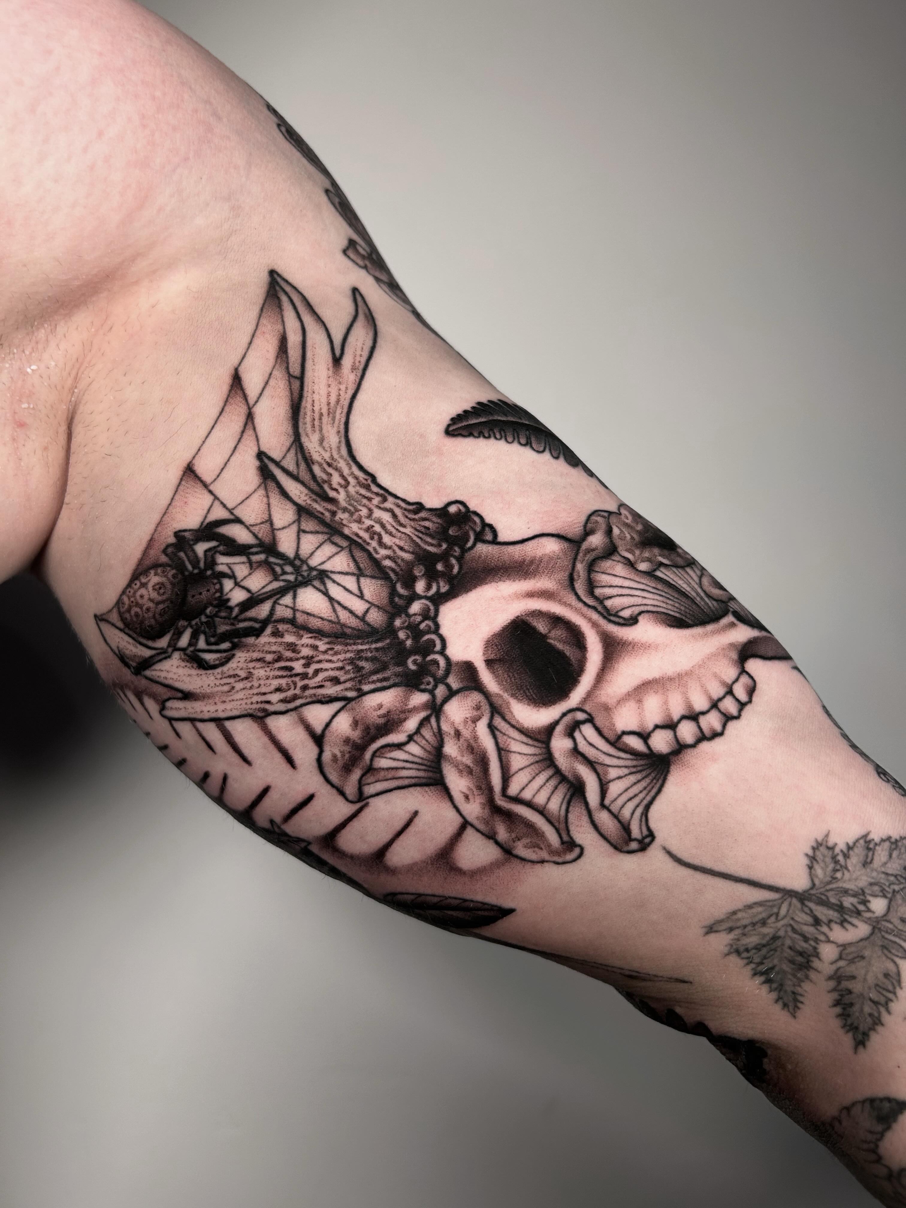 Skull and flowers realism tattoo on the forearm by Salt Lake City tattoo artist