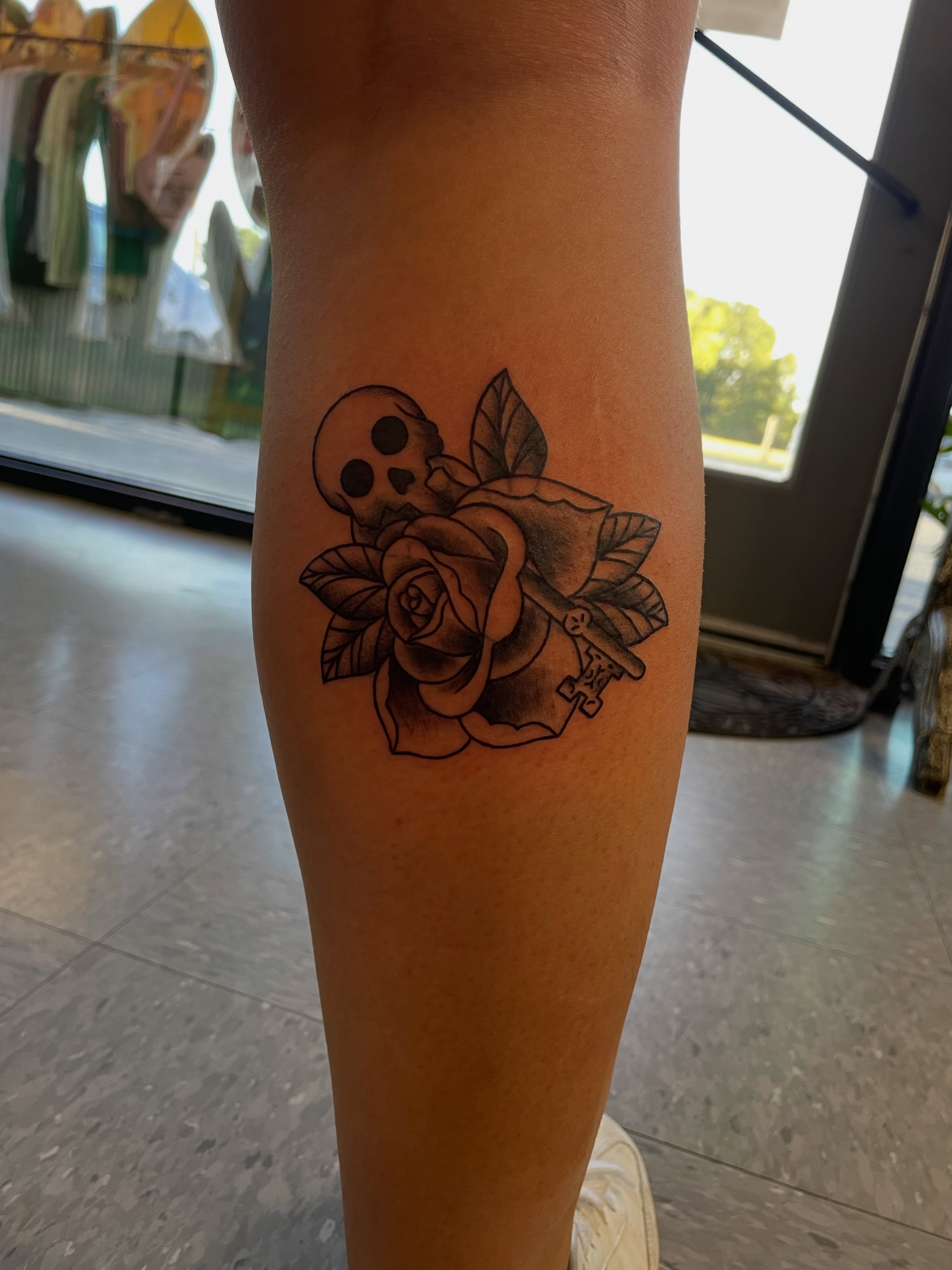 Rose and skull black and grey tattoo on the forearm by Mallory Moore