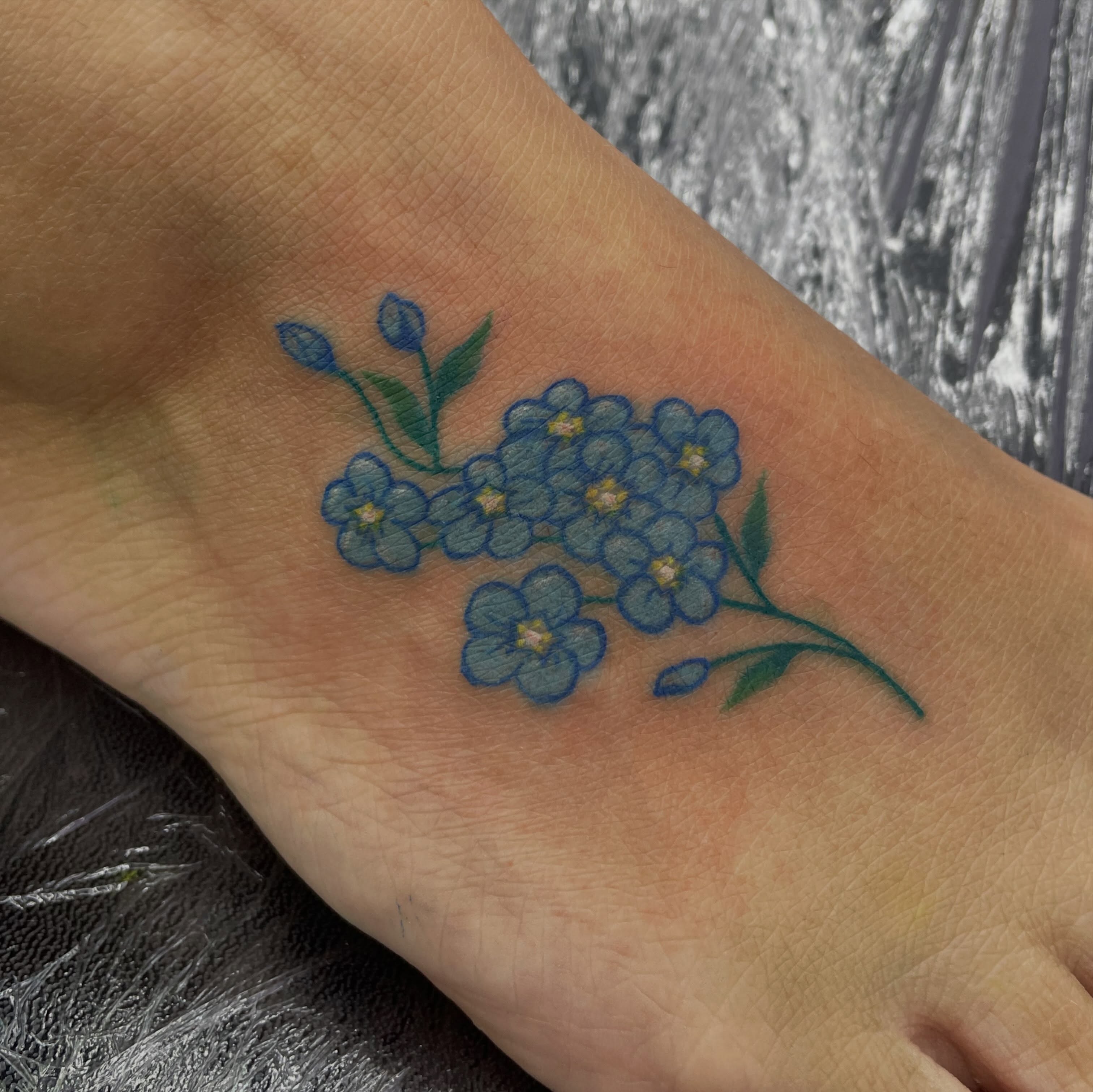 Blue forget-me-not flowers dotwork tattoo on the forearm by elly, Oakham